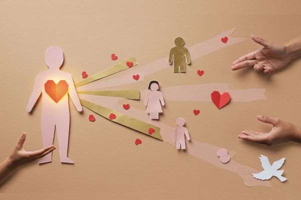 slika prikazuje dječju ruku s lijeve strane i ruke odrasloga s desne, pružene jedne prema drugima, između je slika djeteta od papira sa srcem i trakicama koje vode prema rukama odraslog