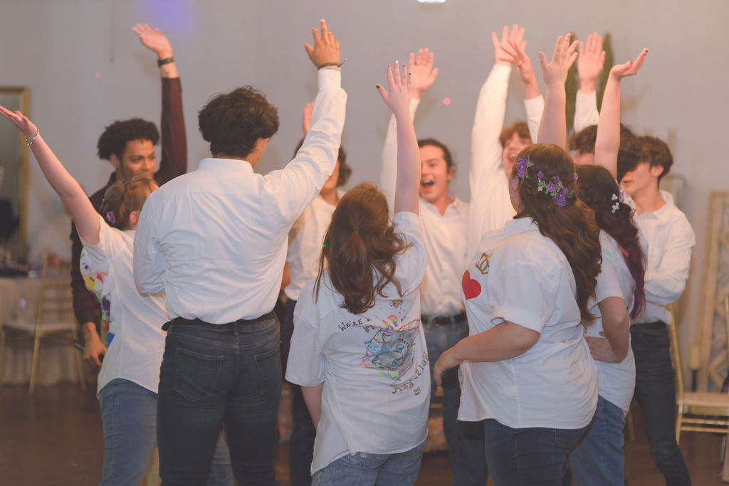 Iliana and her court of honor celebrating with a fun, casual dance during her Alice in Wonderland quinceanera, showcasing the playful and whimsical spirit of the Alice in Wonderland quince theme.