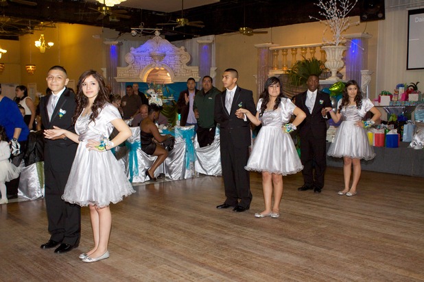 Quinceañera court members standing in formation on the dance floor during the entrance of the quinceanera program.