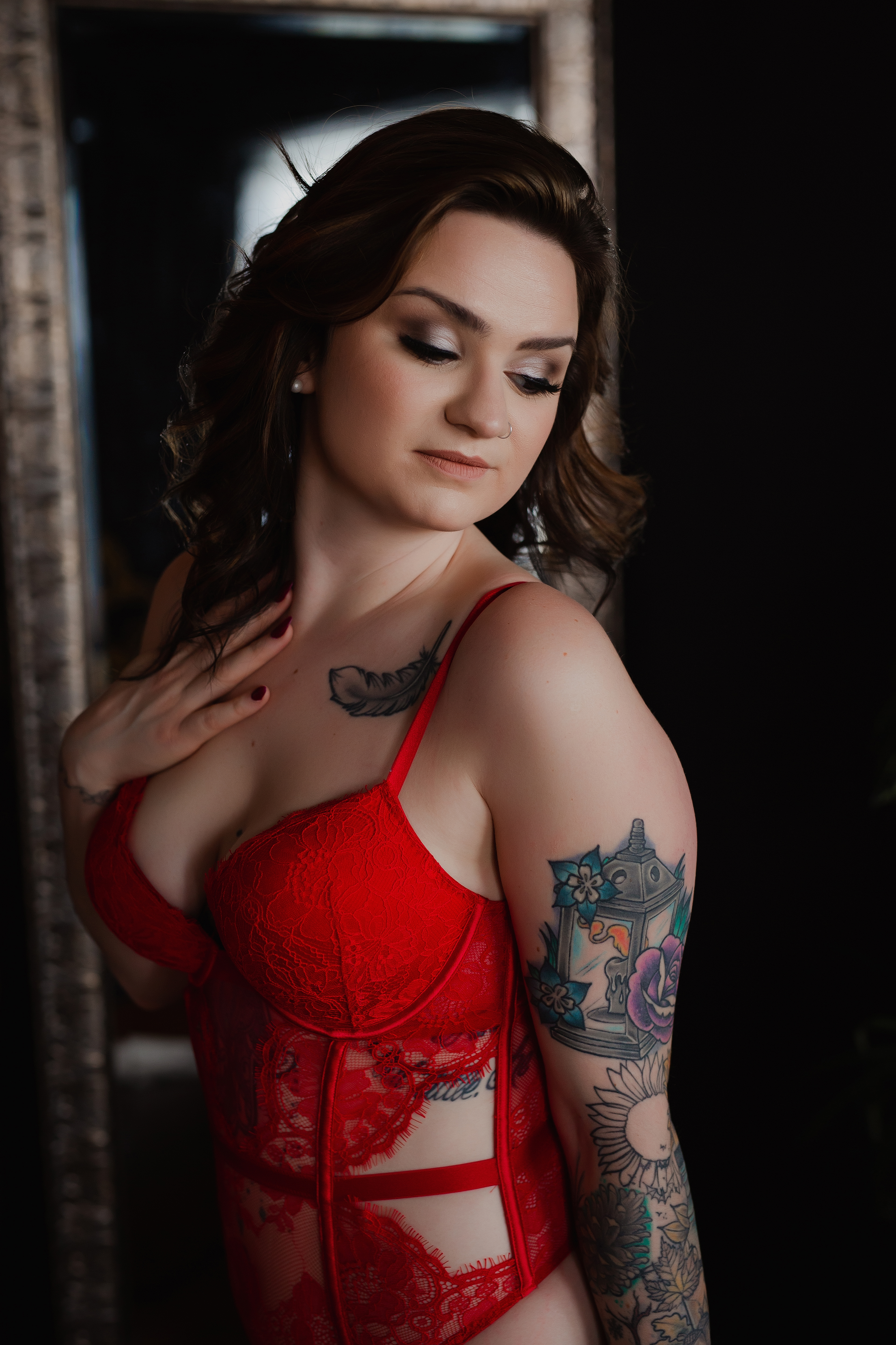 Professional boudoir photography of a tattooed woman in red lace lingerie, photographed in natural light with a soft, intimate mood. Professional boudoir photography of a tattooed woman in red lace lingerie, photographed in natural light with a soft, intimate mood.