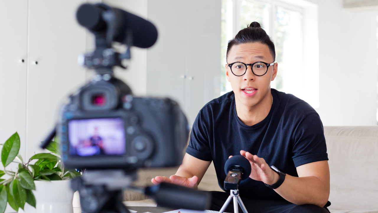 An entrepreneur recording a video blog (vlog) or writing a blog post on a laptop. An entrepreneur recording a video blog (vlog) or writing a blog post on a laptop.