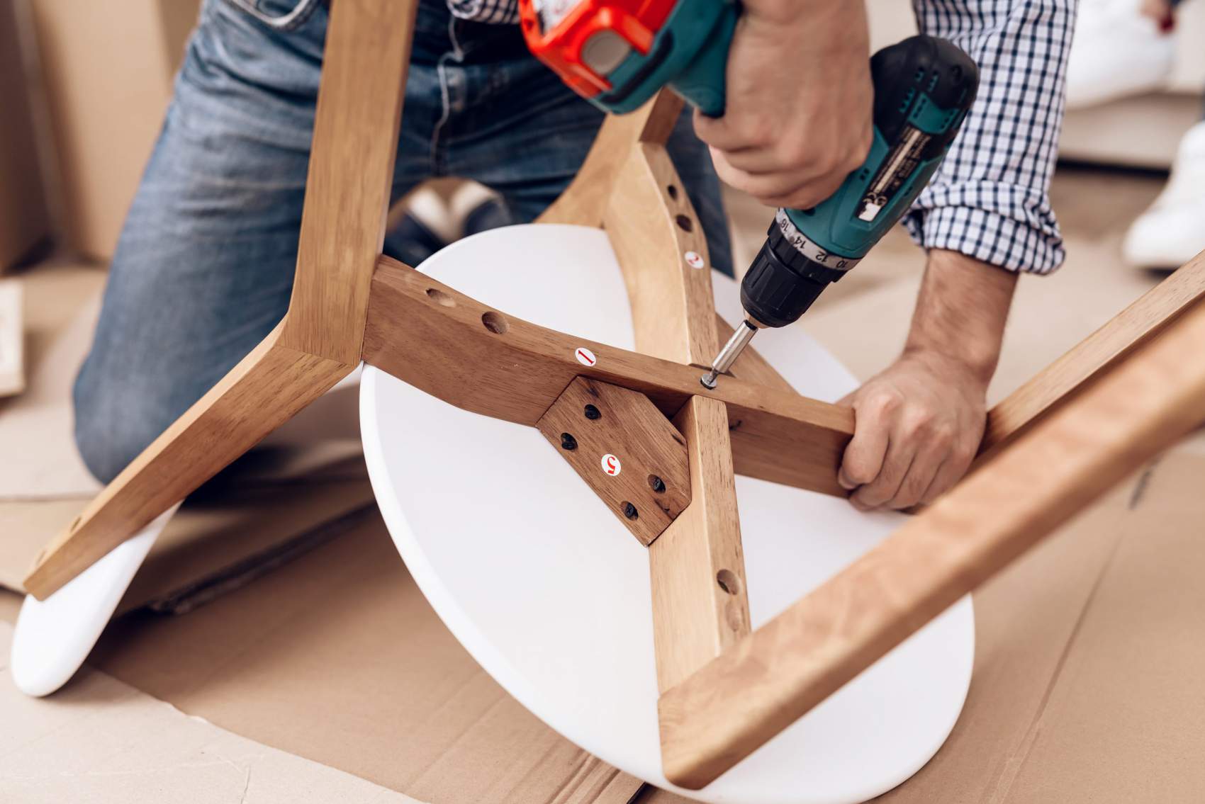 a person using a drill to fix a chair