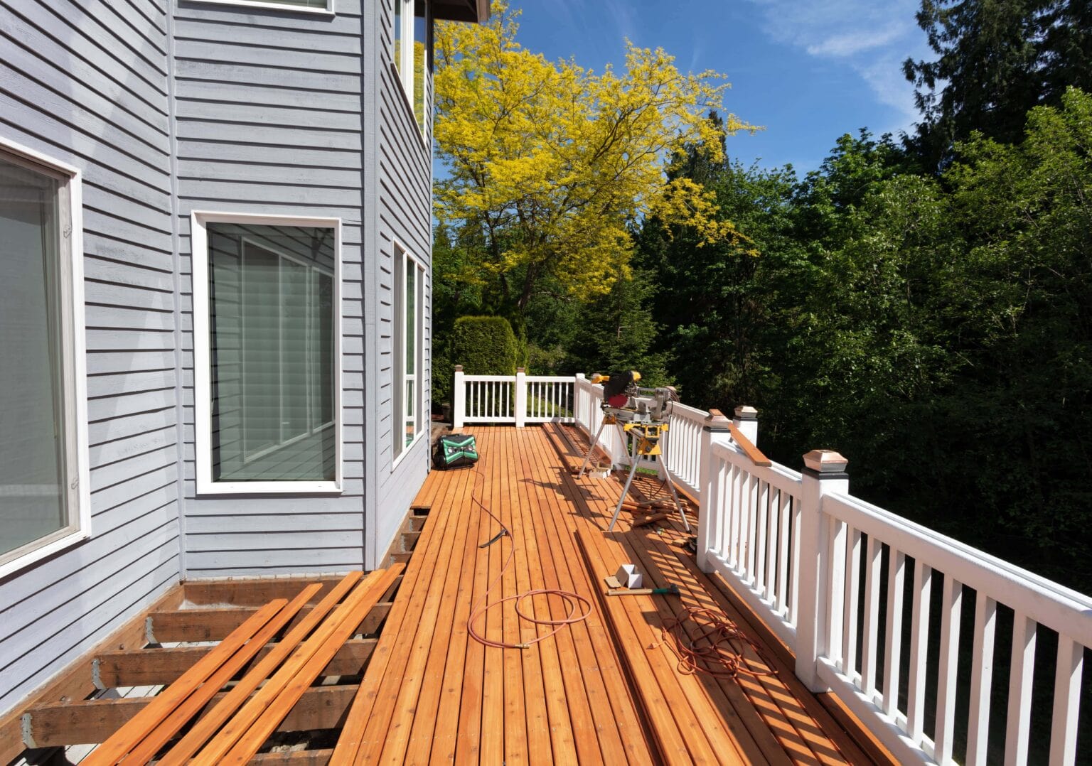 a deck with wood boards and a white railing