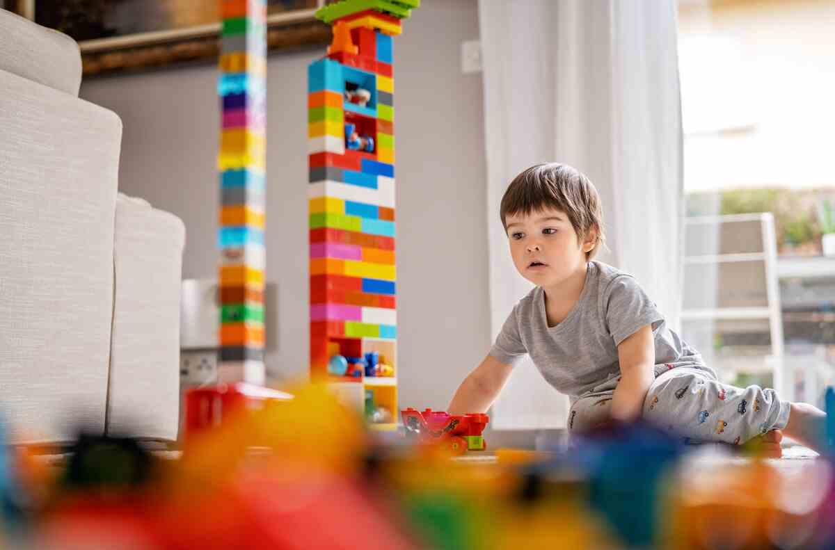 child playing with building blocks tower in an interactive learning environment at home