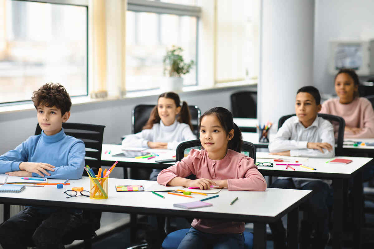 portrait-of-focused-diverse-childs-sitting-at-kindergarten-classroom