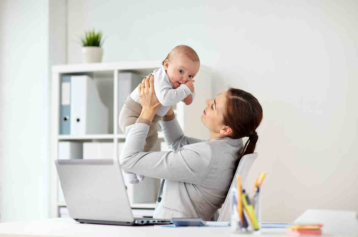 happy-businesswoman-with-baby-and-laptop-at-office-infant-care-tips