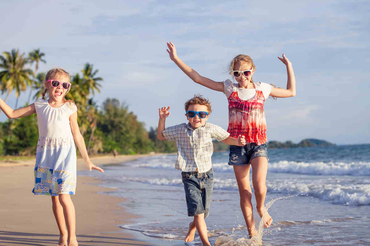 happy-children-playing-on-the-beach-at-the-day