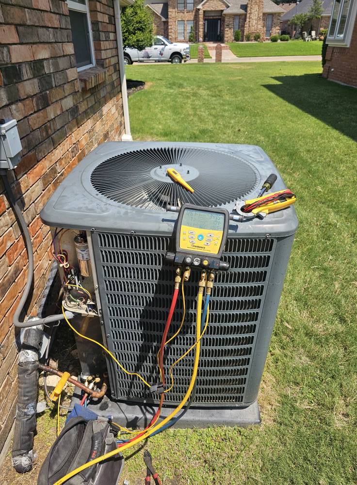 "Big Kountry Air gauges connected to an outdoor air conditioning unit during HVAC maintenance at a North Texas home."