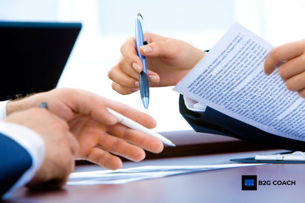 Business owner reviewing contract strategy with government forms Business owner reviewing contract strategy with government forms