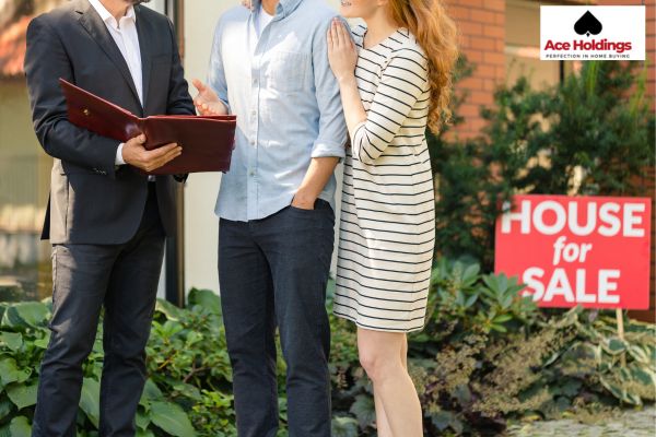 man in a suite talking to a couple with big notebook