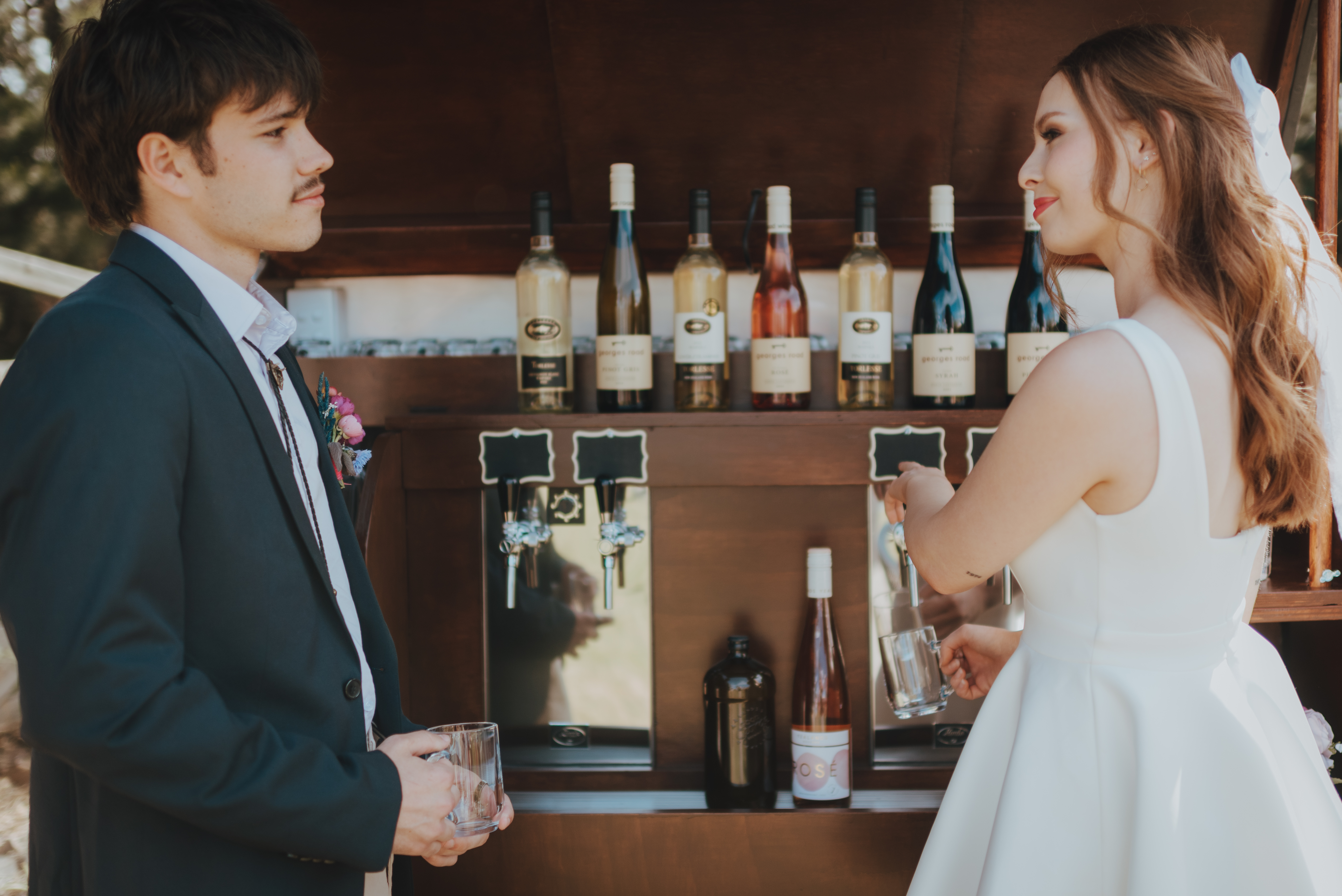 newlyweds looking at each-other while having a quick drink newlyweds looking at each-other while having a quick drink