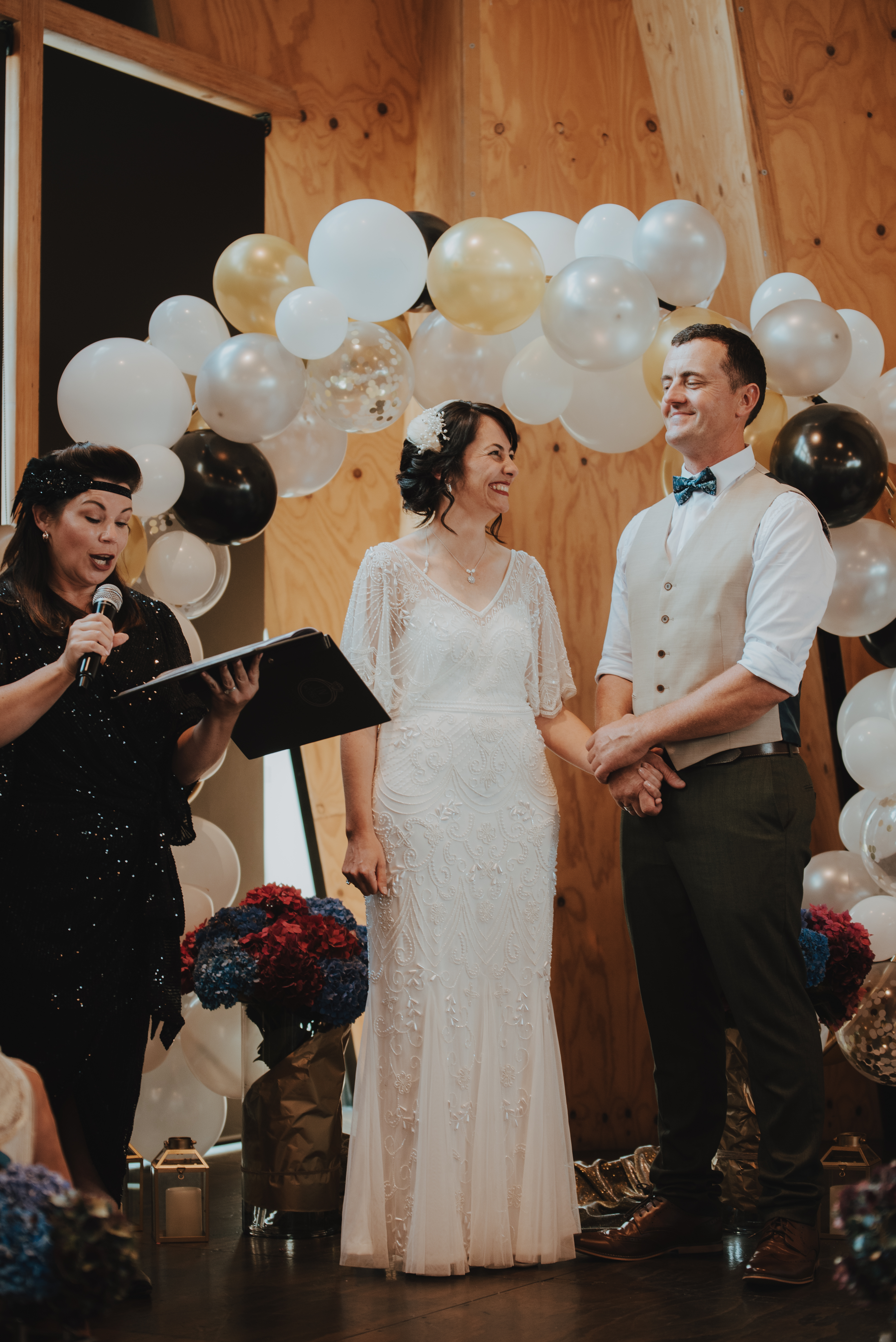 ceremony in full sway, couple holding hands laughing while celebrant speaks ceremony in full sway, couple holding hands laughing while celebrant speaks