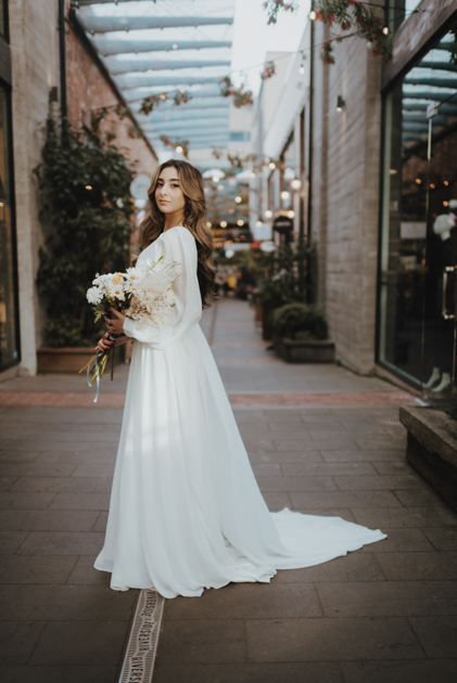 bride standing with bouquet in christchurch cbd alleyway