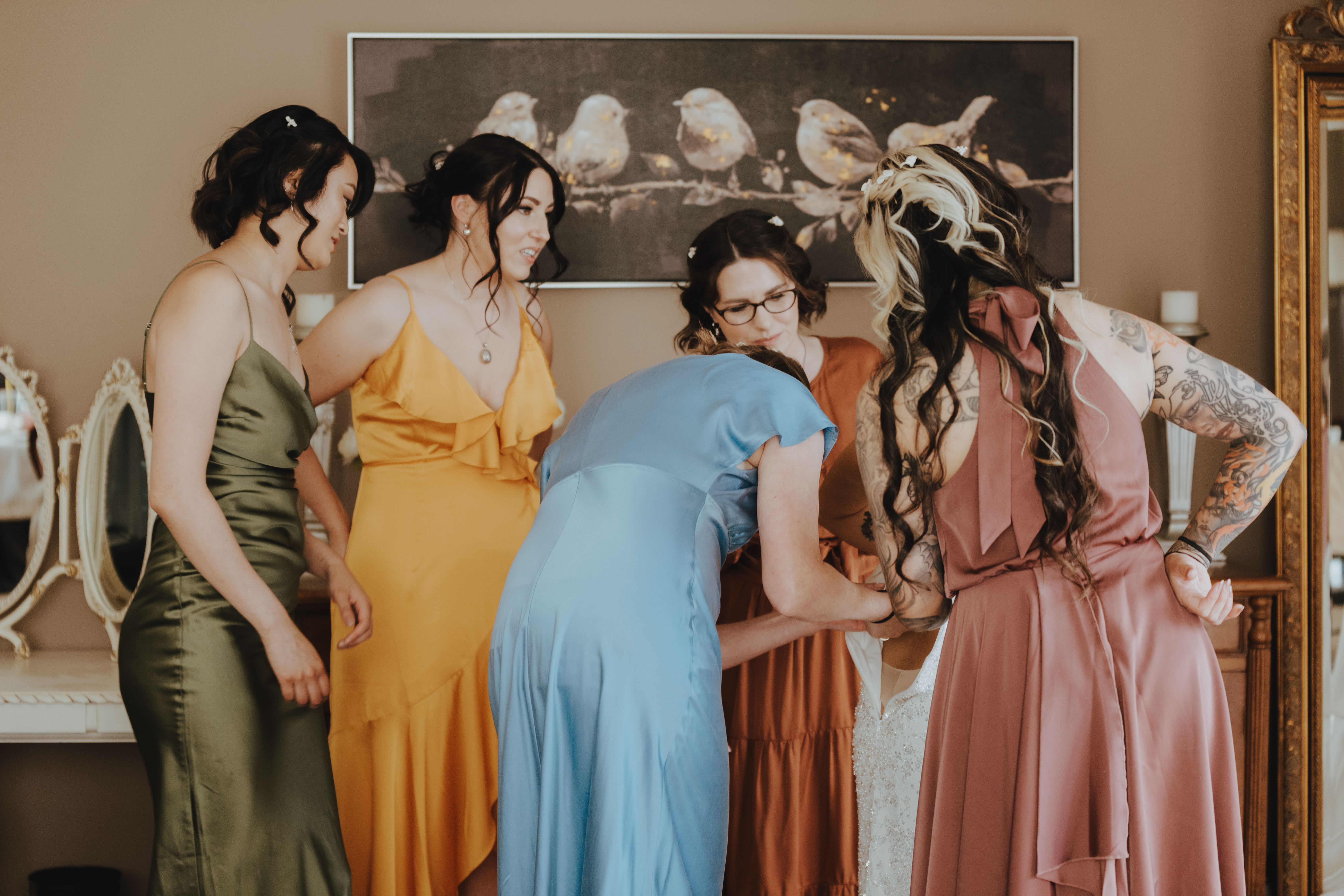 bride being fussed over by her bridesmaids