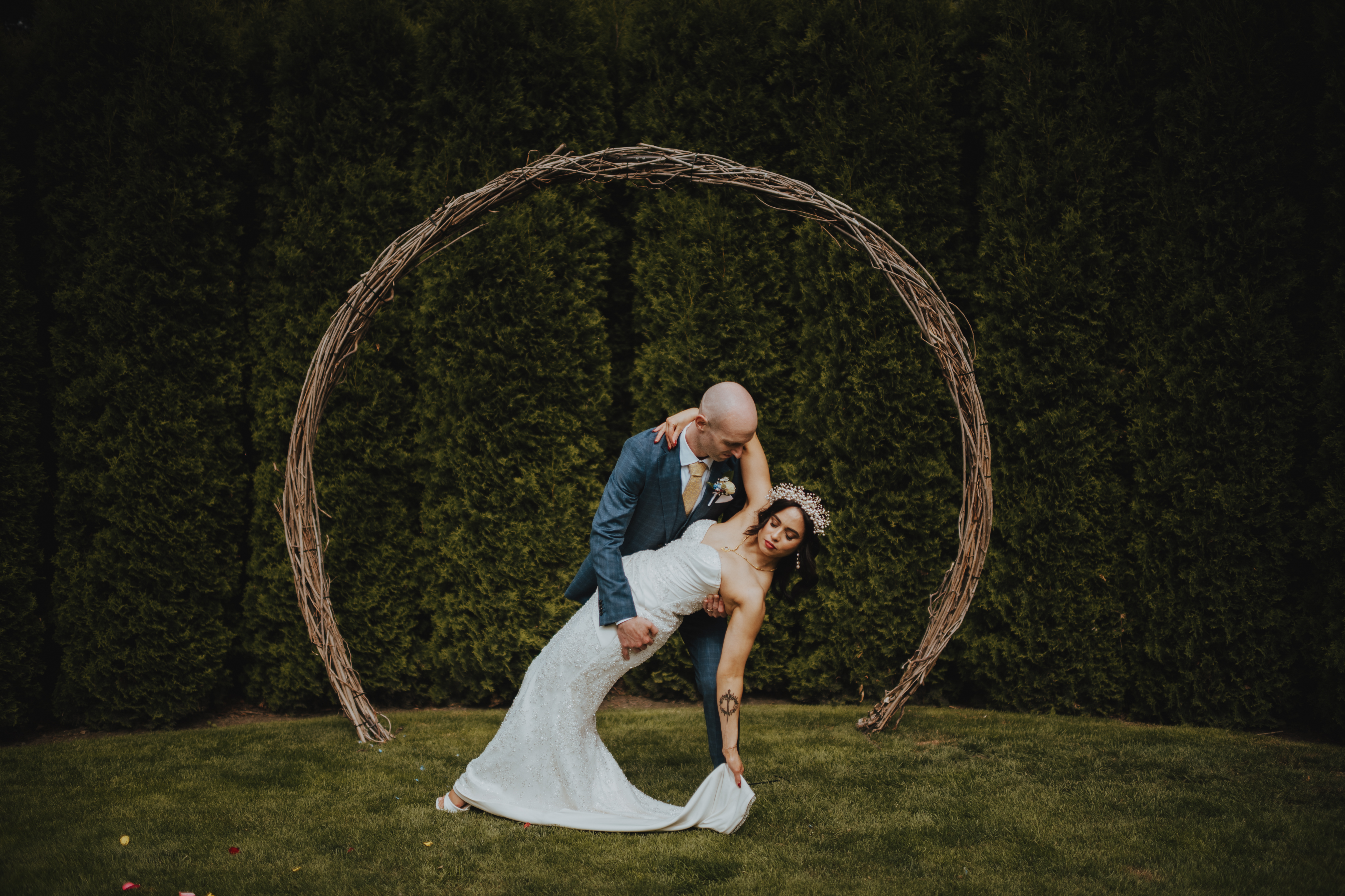 newlyweds in front of hedge for portraits