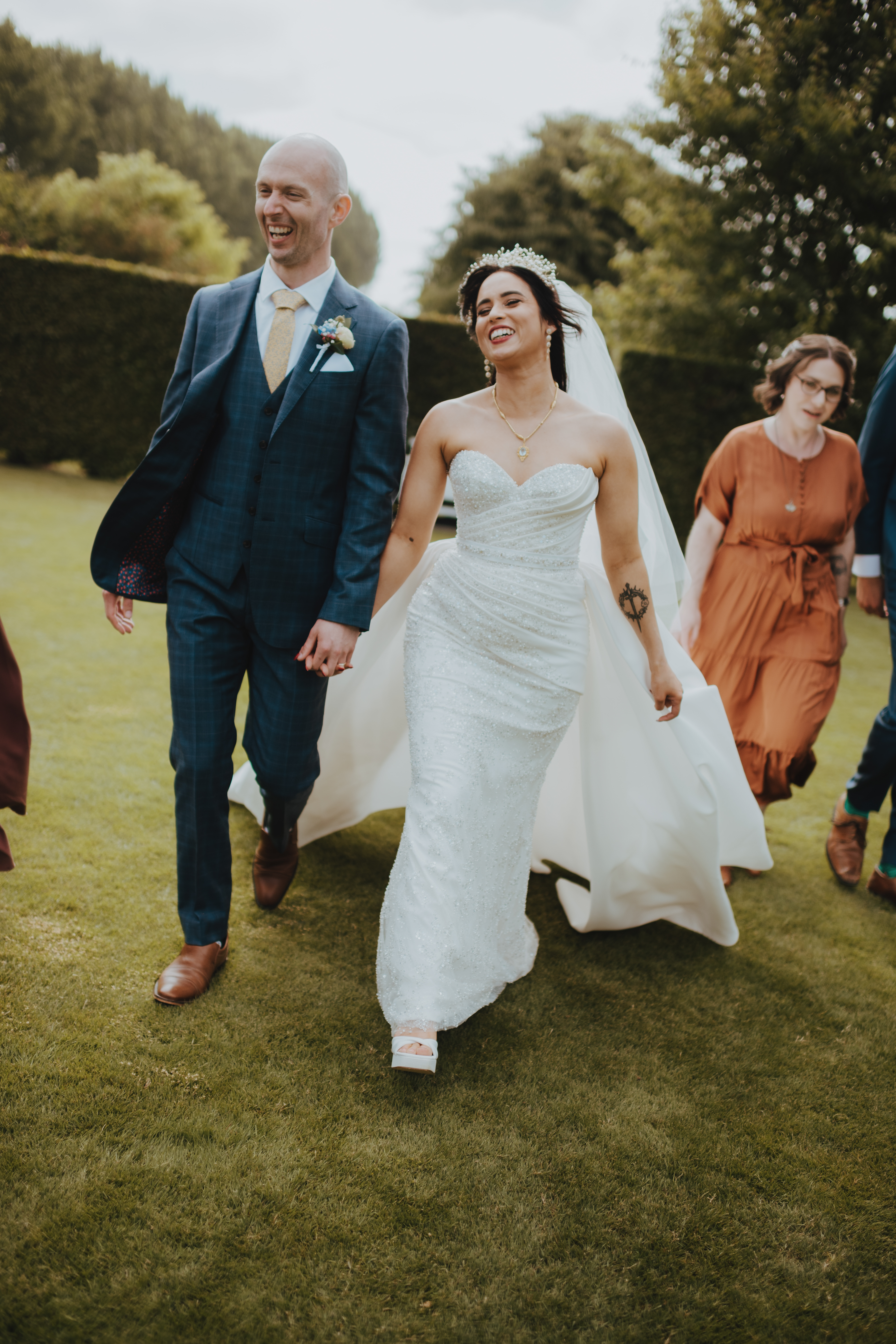 bride and groom laughing walking through the garden