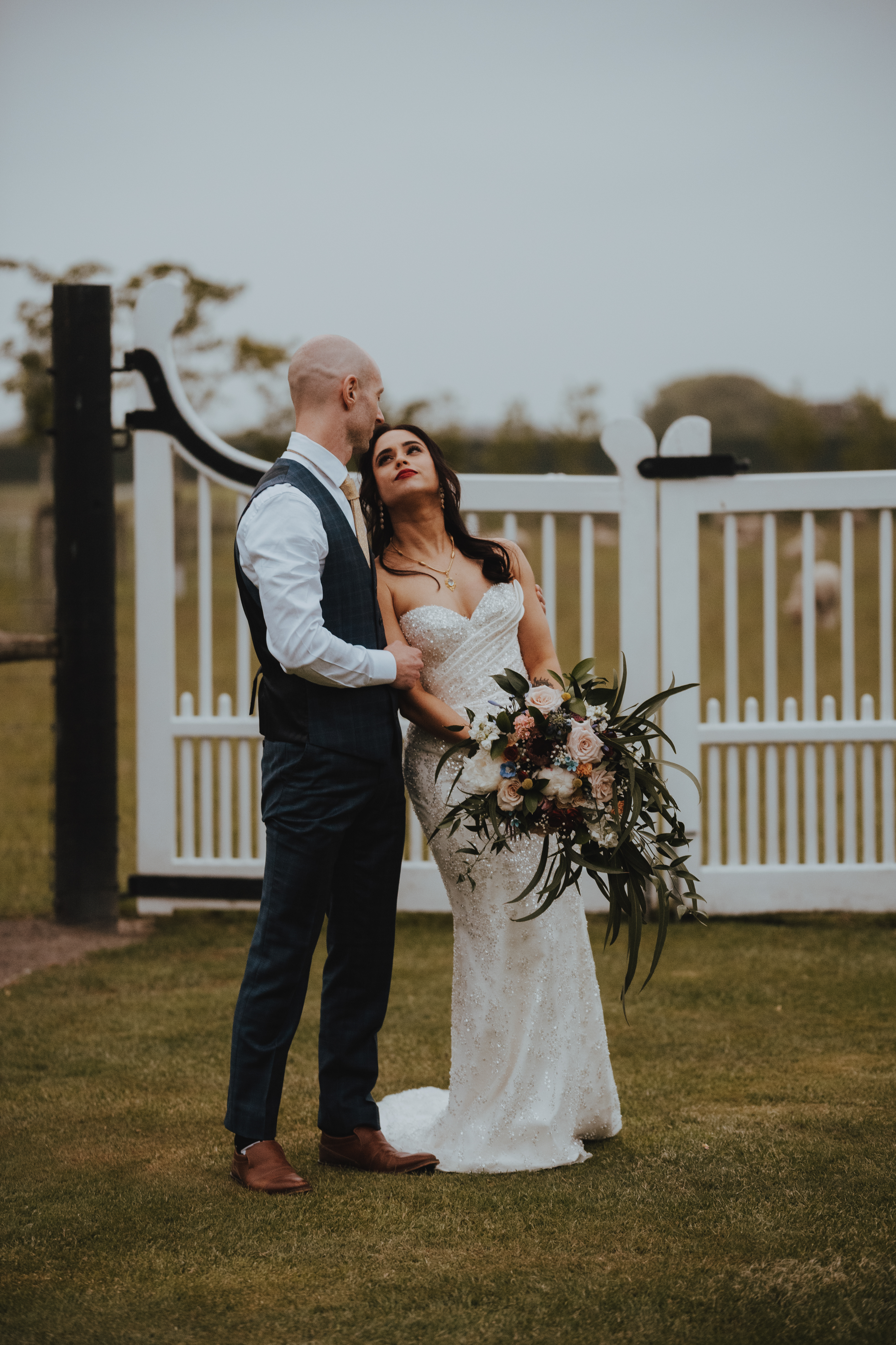 newlyweds cuddling up under a dark sunset