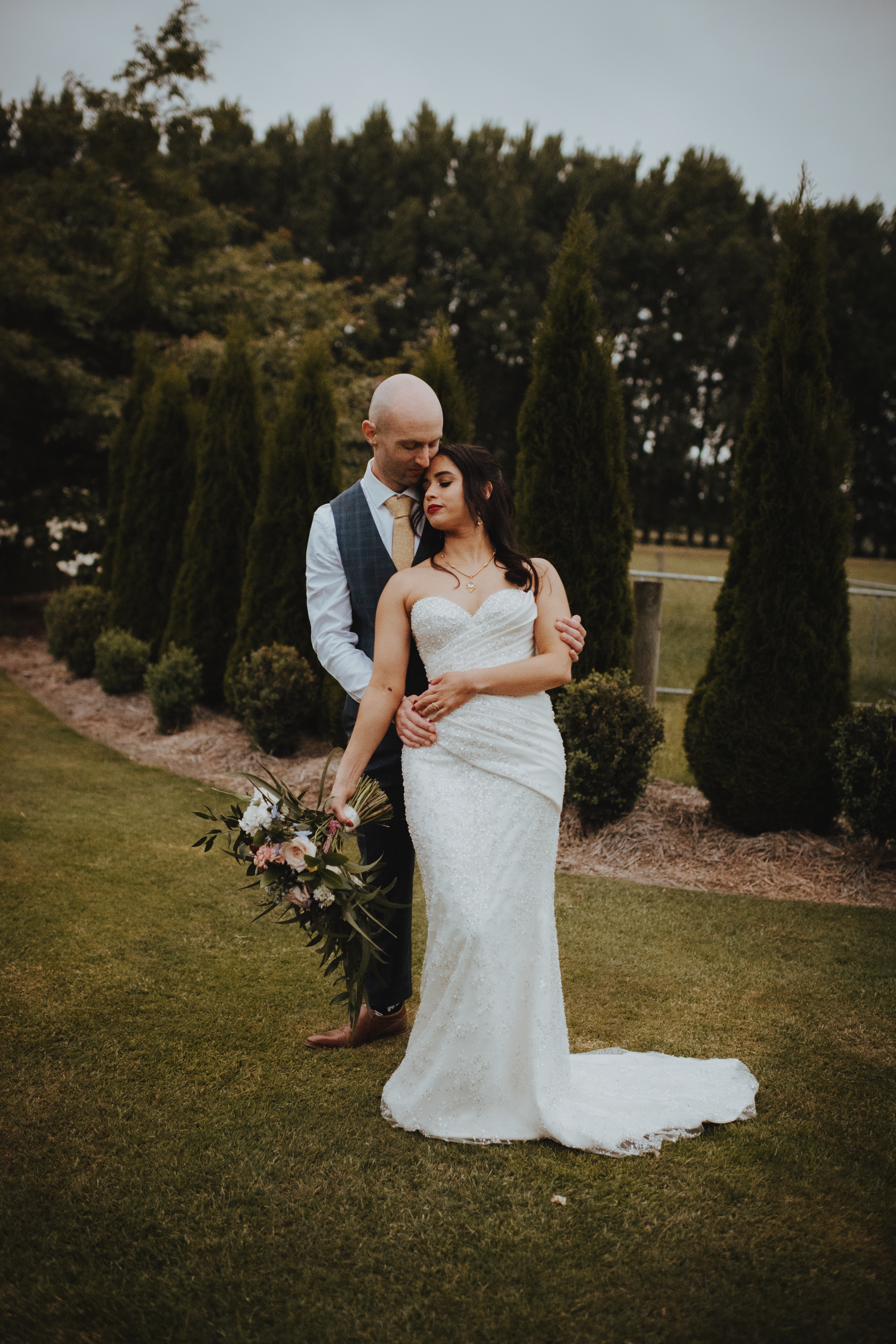 newlyweds cuddling under a setting sun at Lacebark wedding venue