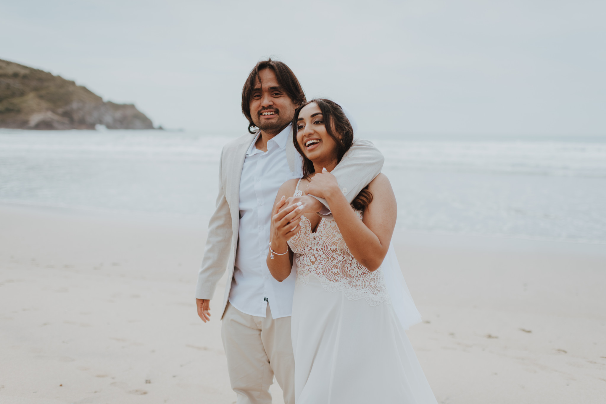 newlyweds laughing on the beach after their ceremony