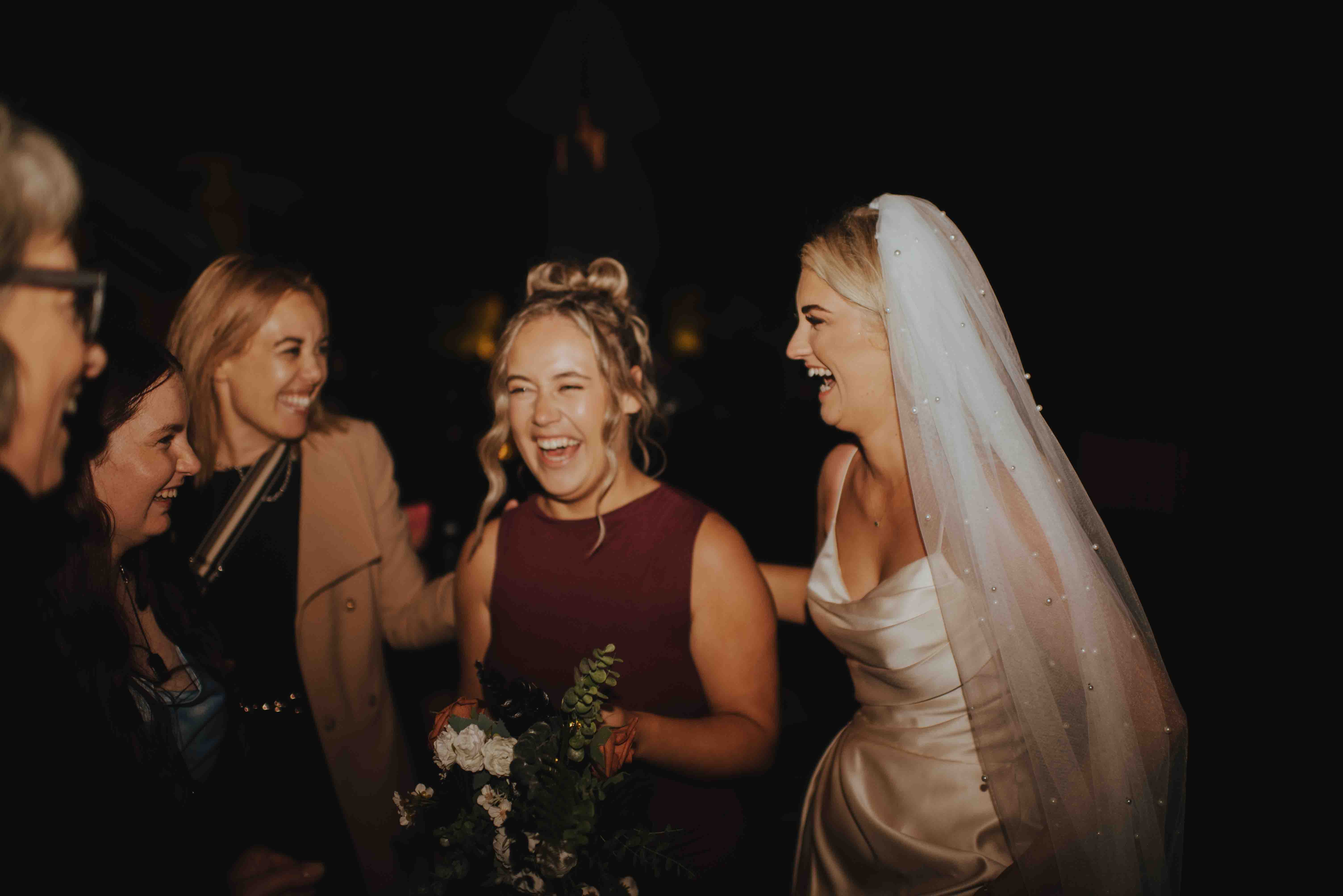 bouquet toss winner laughing with bride