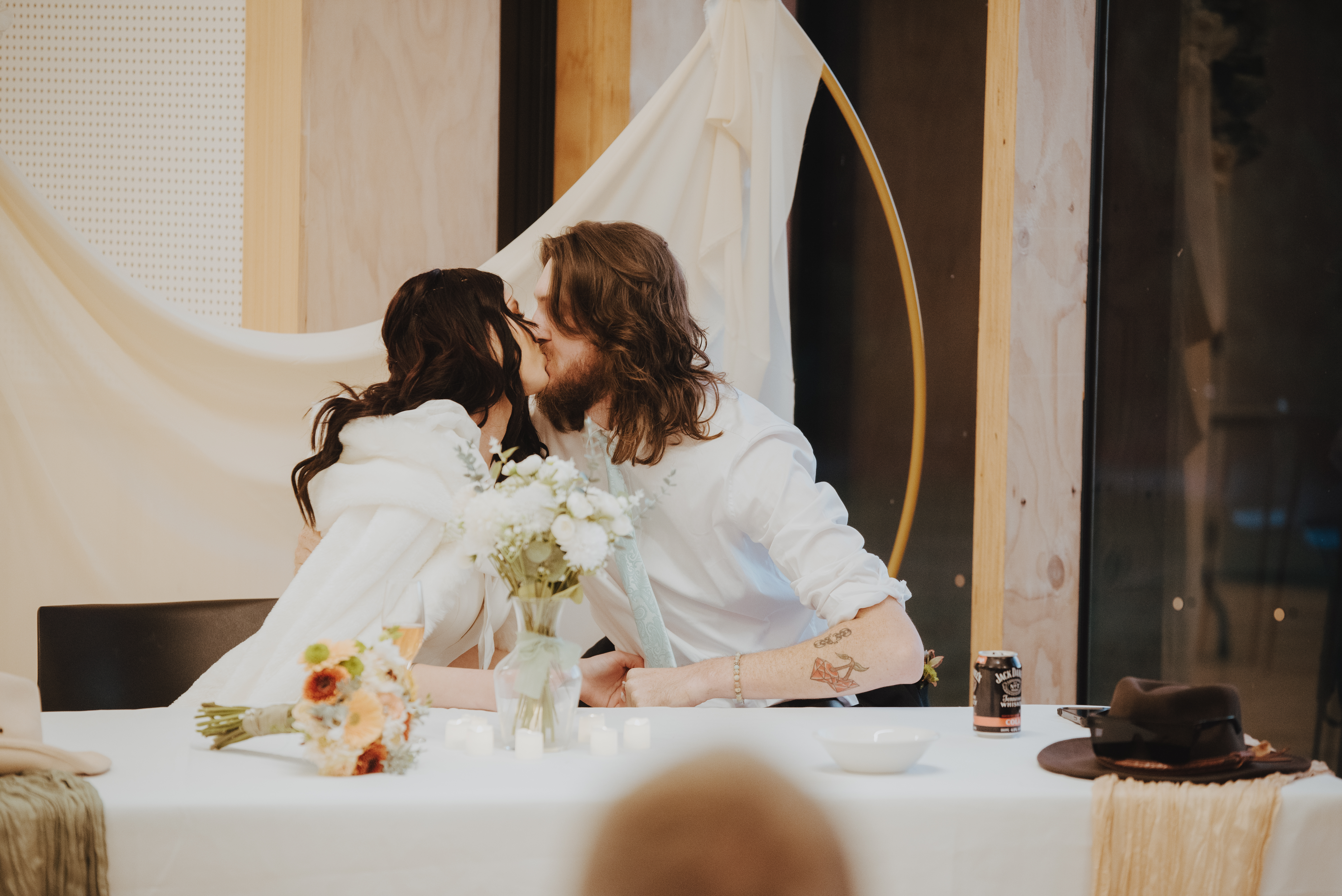 newlyweds getting a kiss in during the speeches