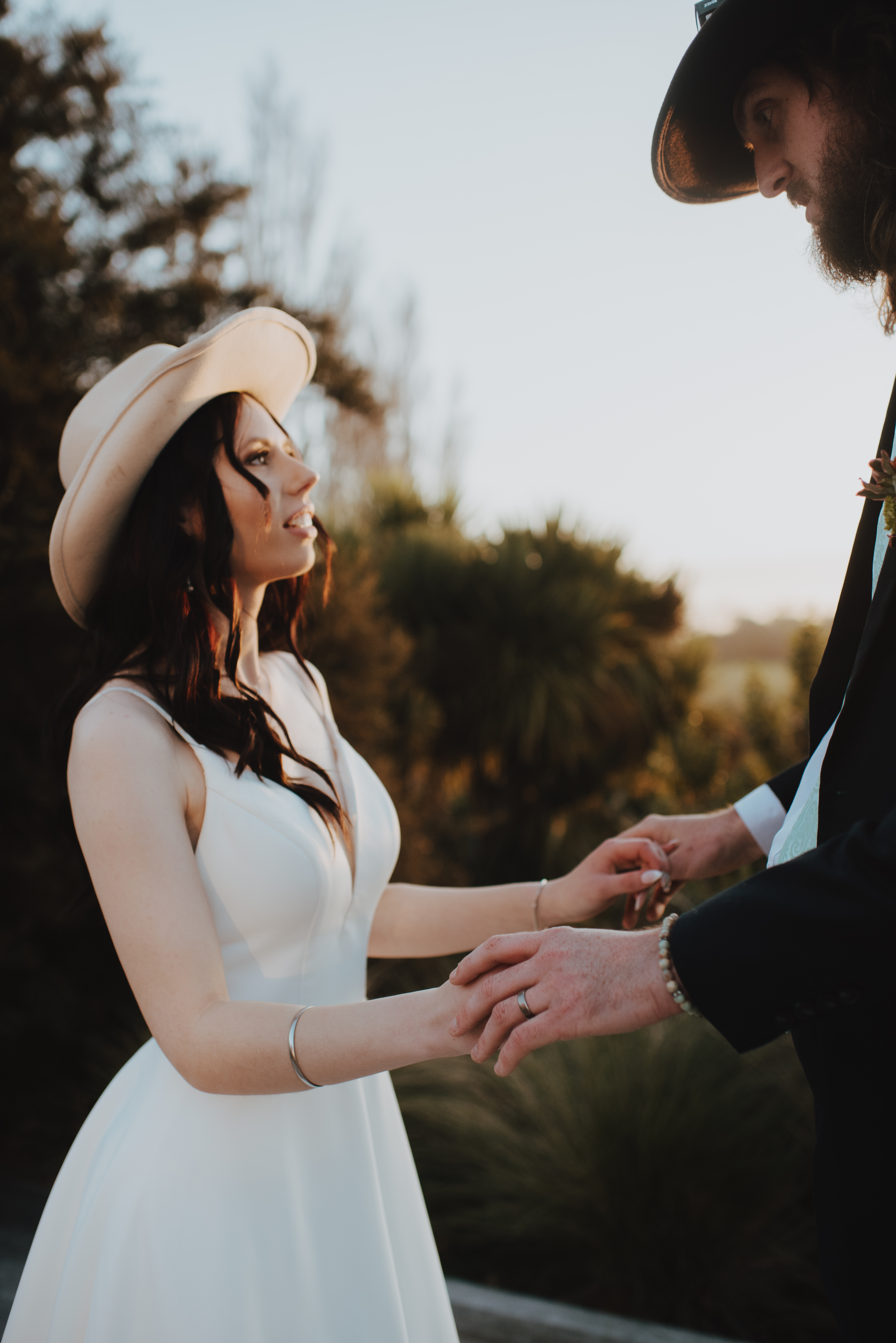 bride and groom hugging with the sun in the background setting