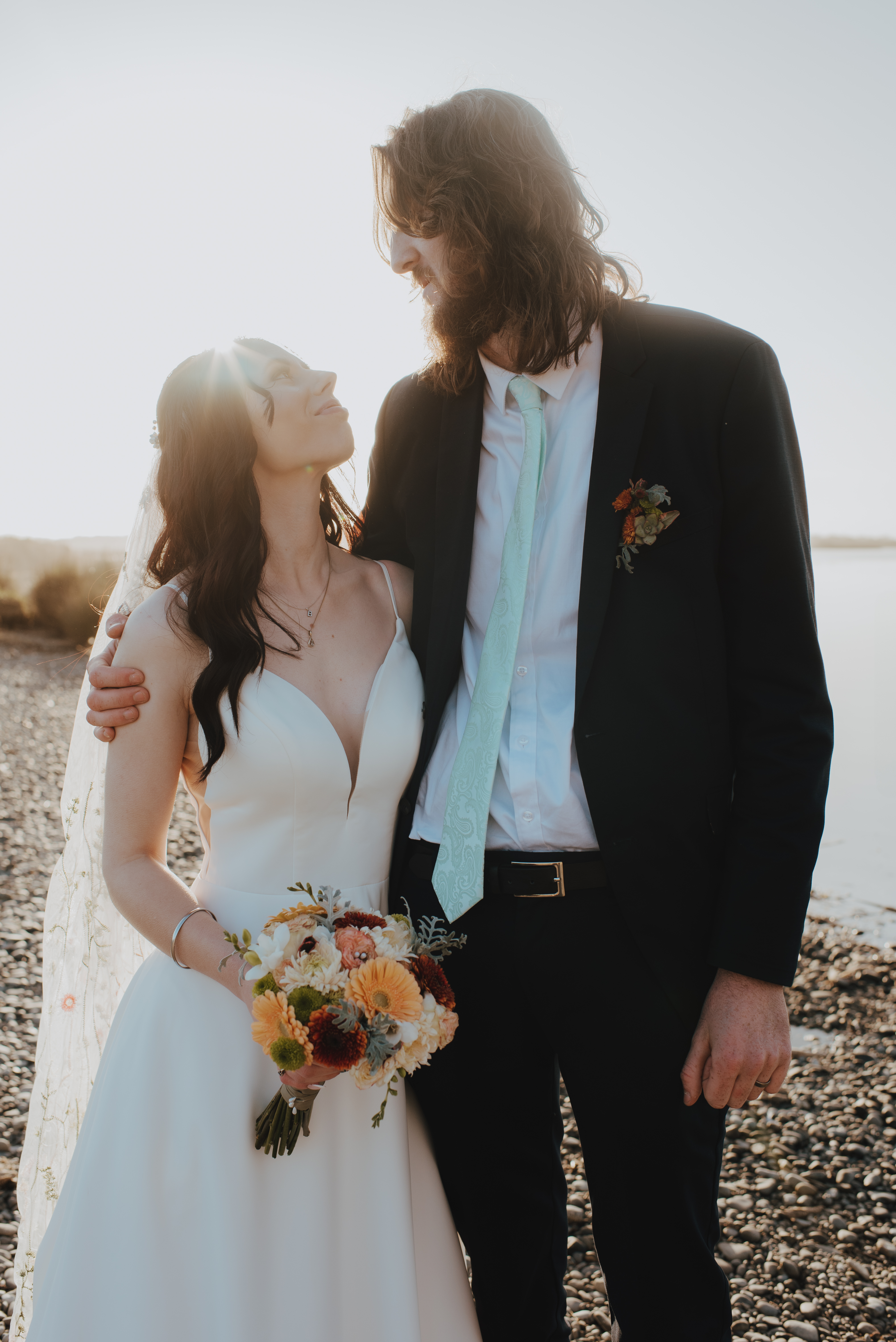 newlyweds hugging at lake edge