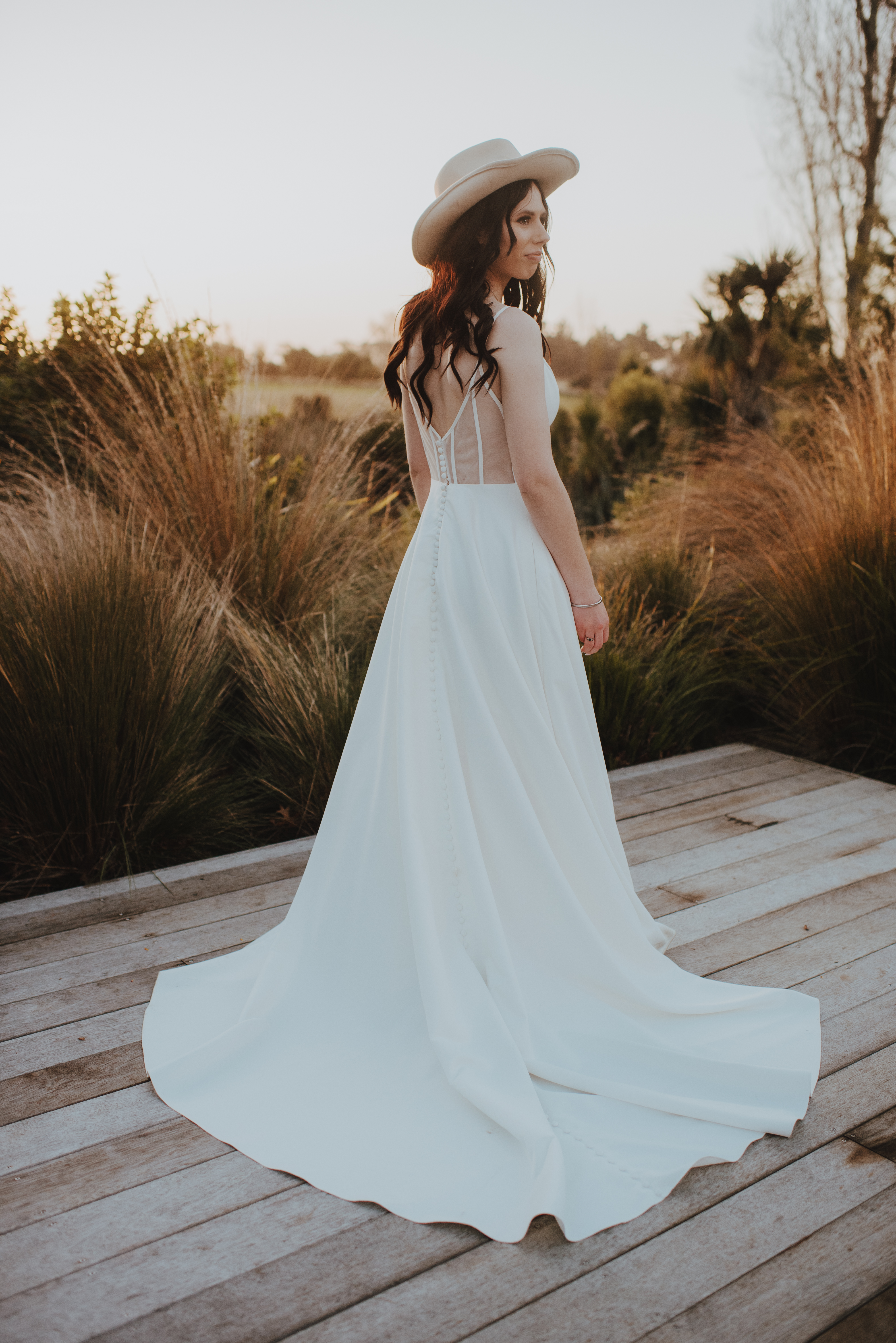 bride looking over her shoulder at groom during sunset