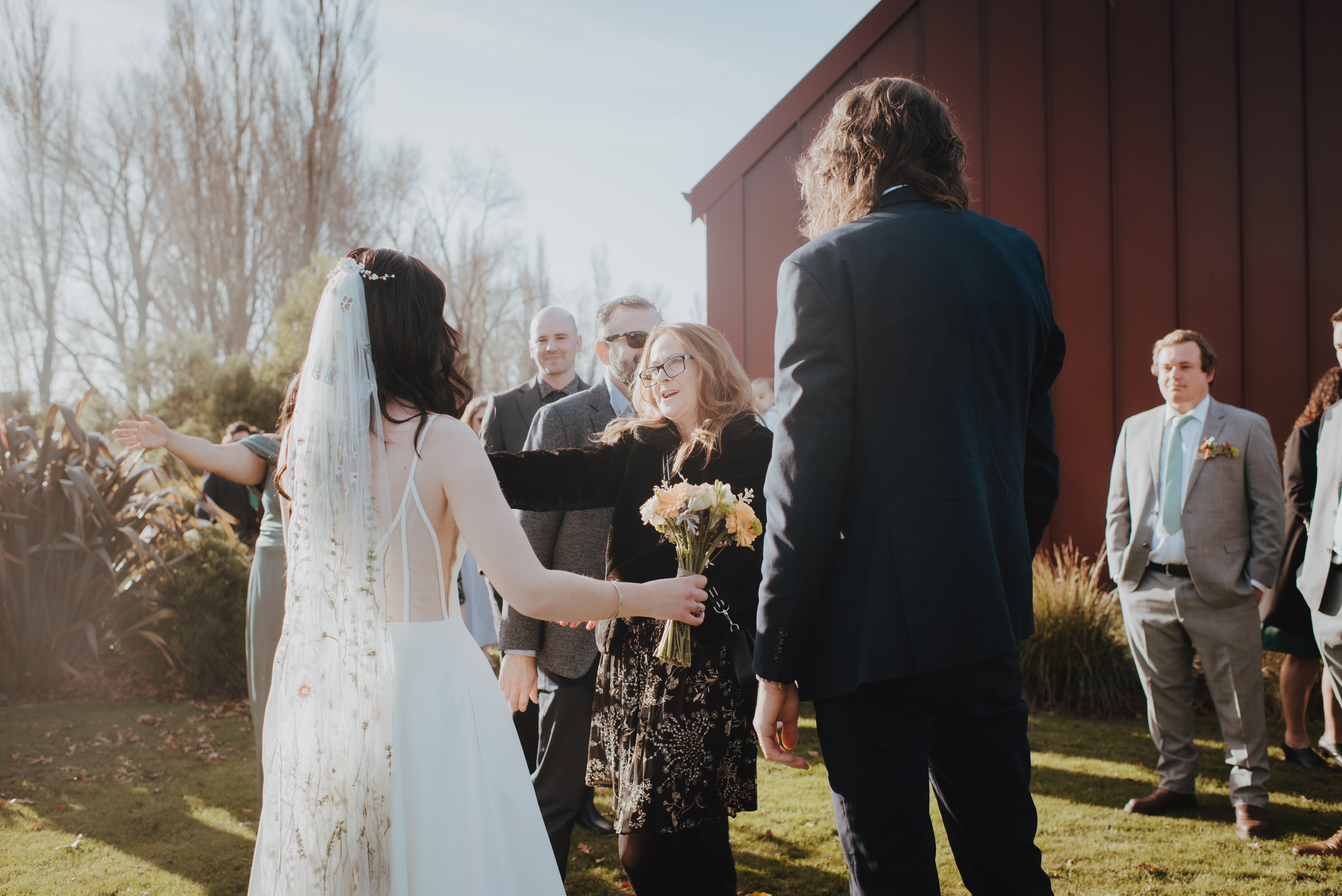 guest reaching to hug the newlyweds