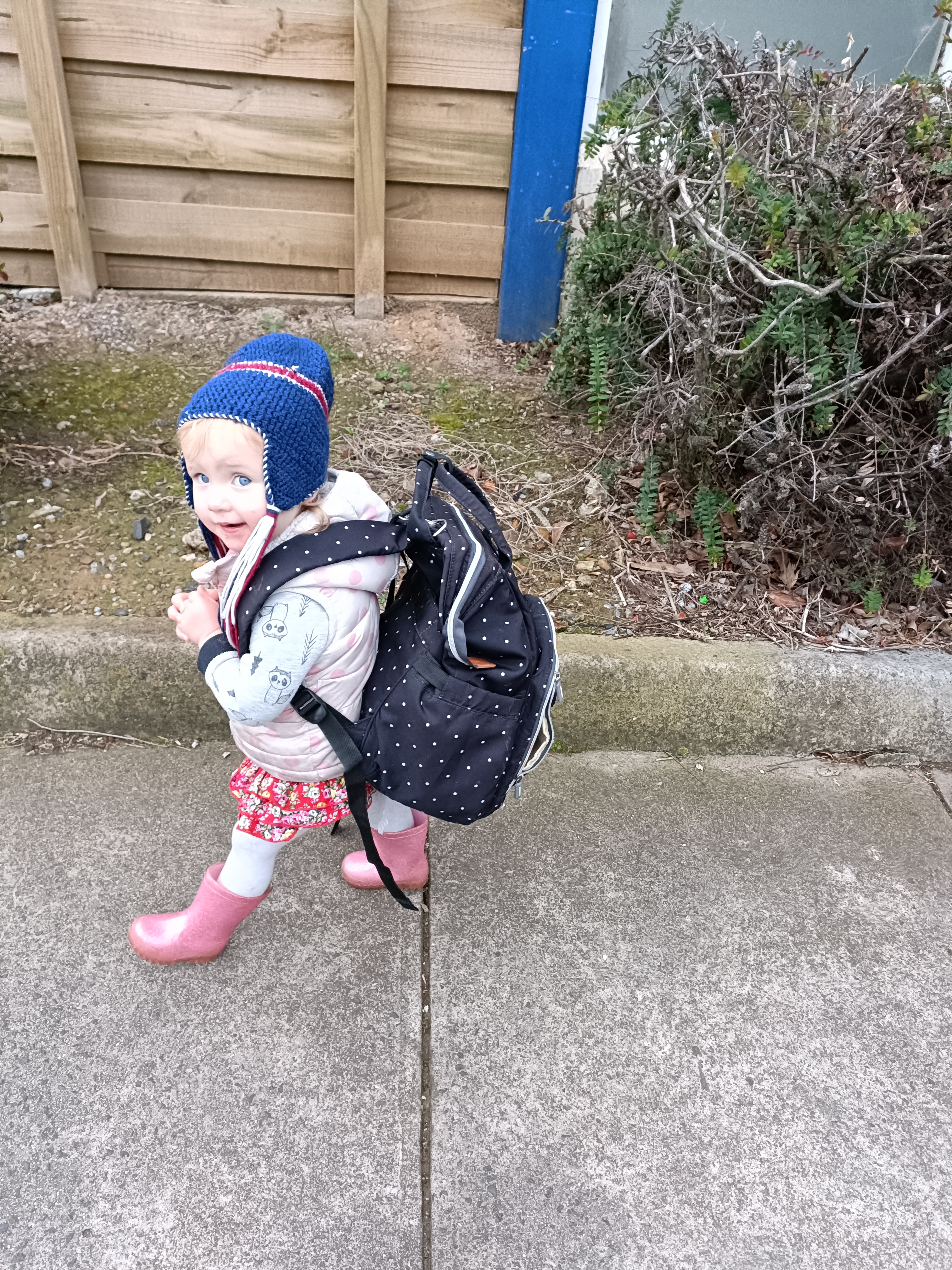 Cute toddler with gumboots and a backpack walking Cute toddler with gumboots and a backpack walking