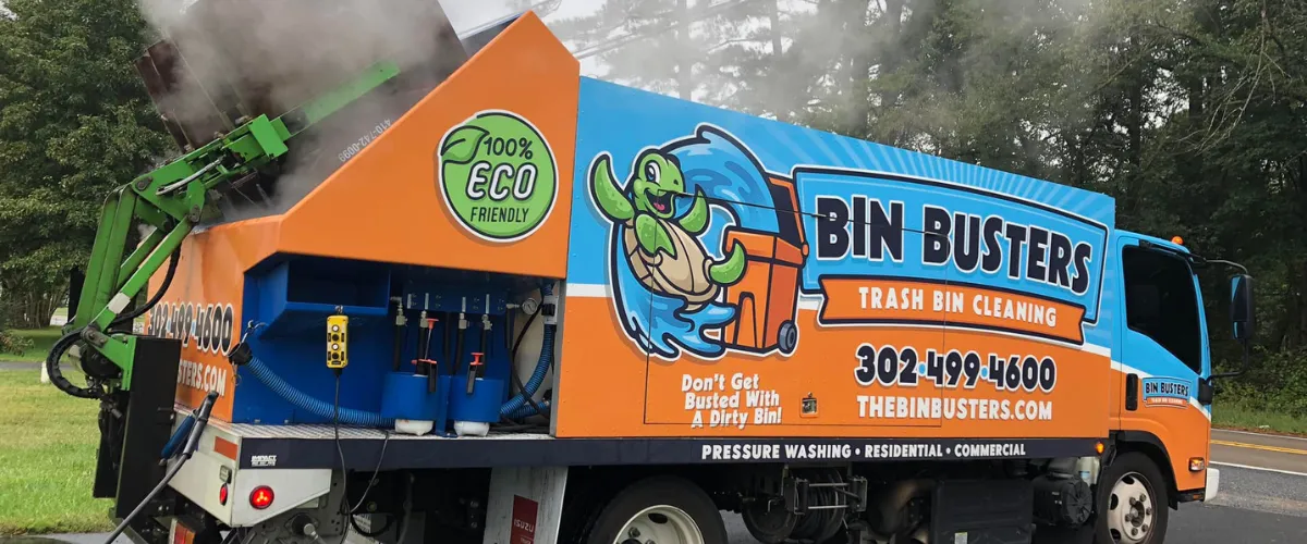 Bin Busters truck releasing steam during trash bin cleaning.