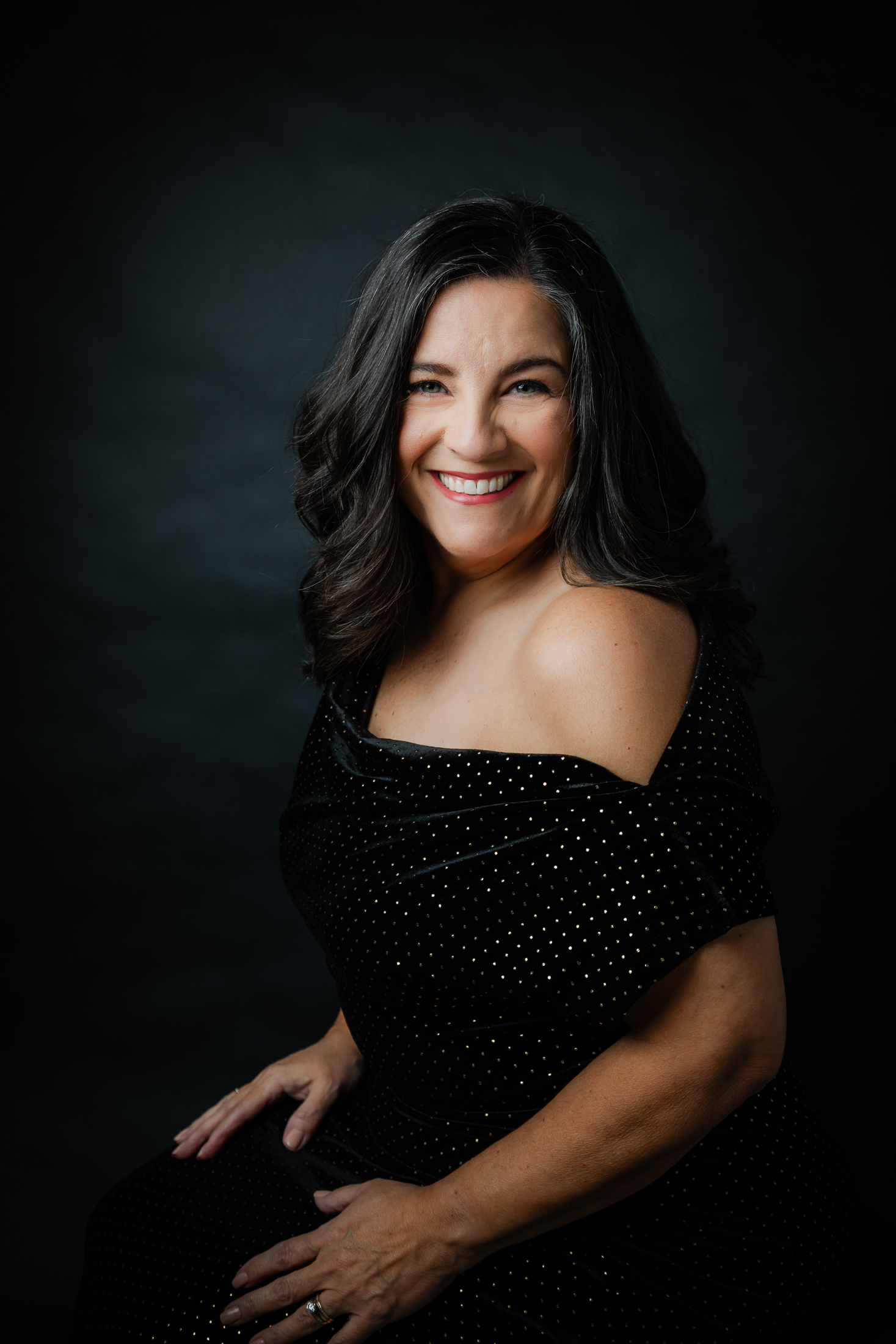 White woman over 50 with dark hairwearing an evening gown with professional hair and makeup styling doing a professional studio photo shoot in Houston TX with Amanda Faucett Photography