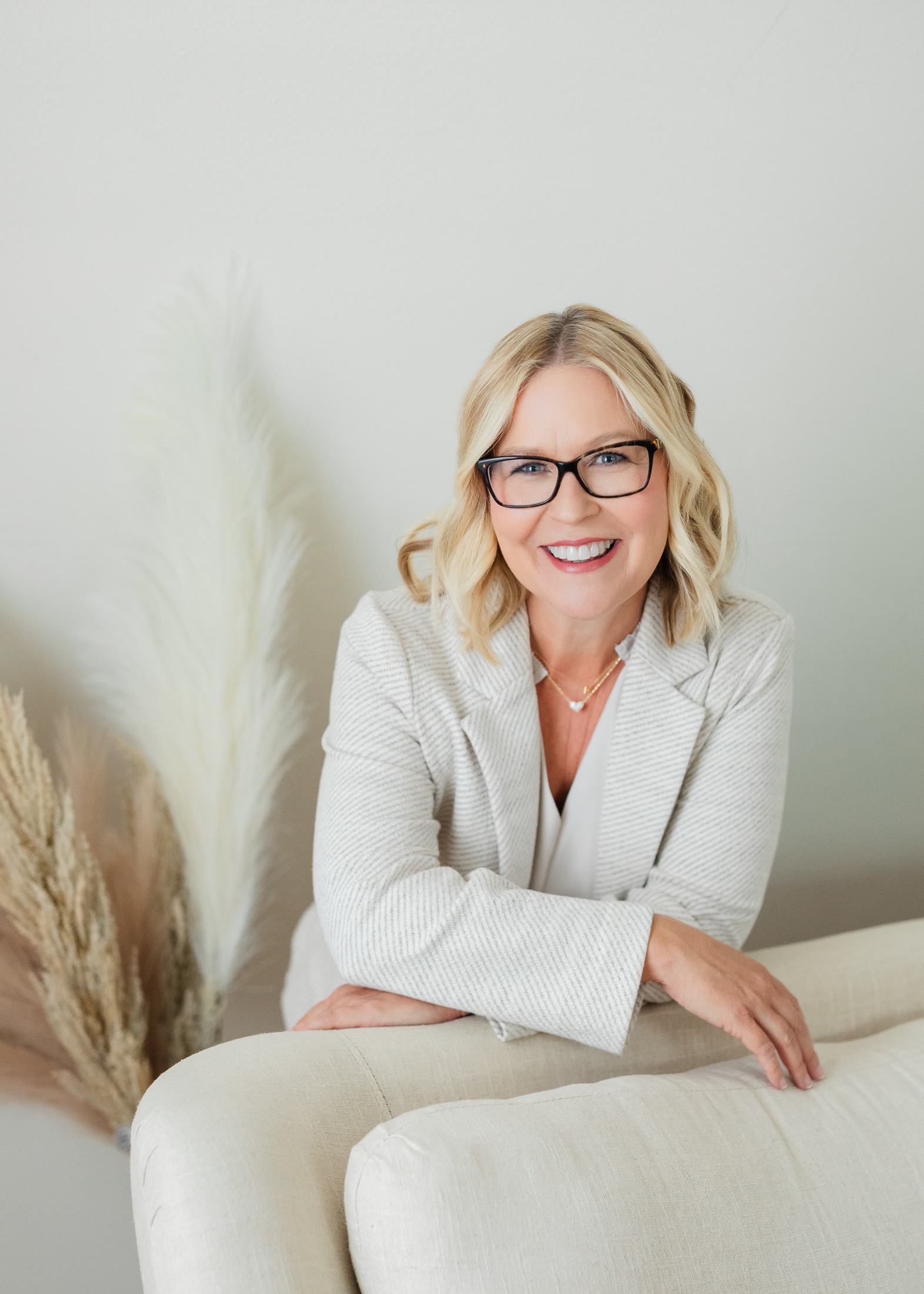 White woman over 50 with blonde hair and wearing a blazer with professional hair and makeup styling doing a professional studio photo shoot in Houston TX with Amanda Faucett Photography