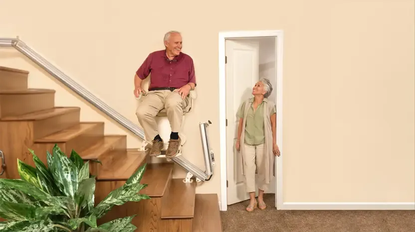 A happy couple using a home stairlift safely.