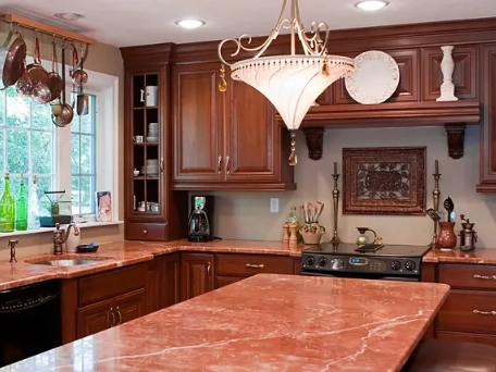 a stylish kitchen remodeling with rich wood cabinets and a striking red marble countertop.