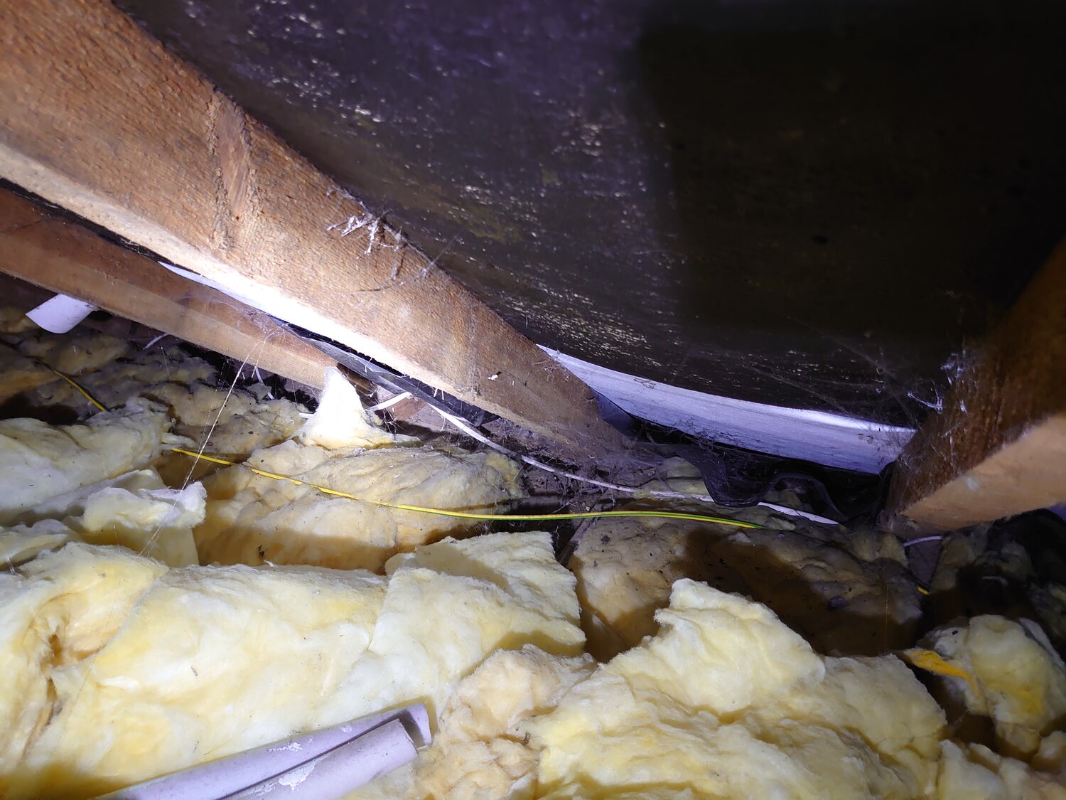 Photograph within roof space showing missing loft insulation