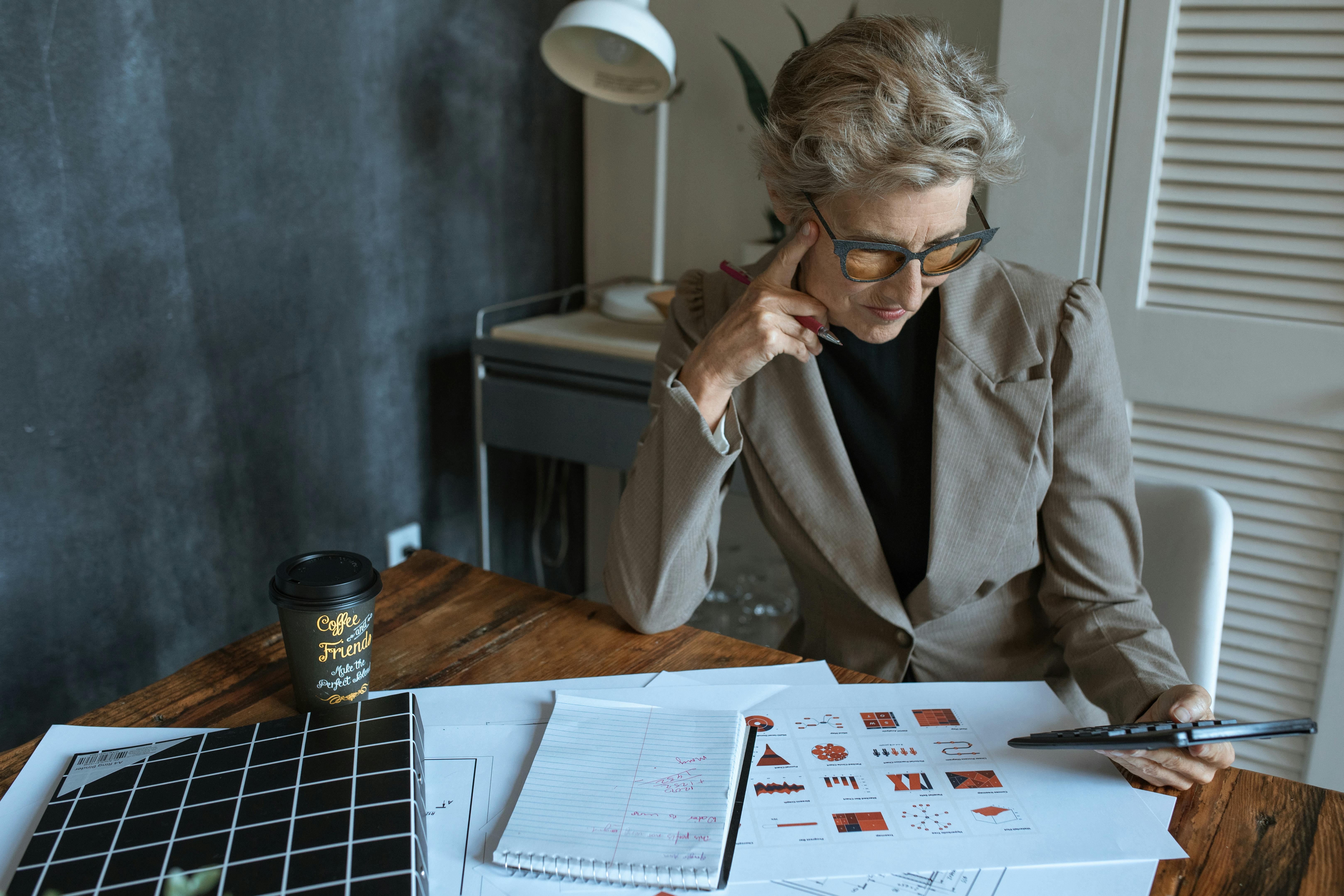 A nonprofit director meticulously reviews grant proposal drafts and financial reports, highlighting the detailed work required to find funding relief in New Orleans.