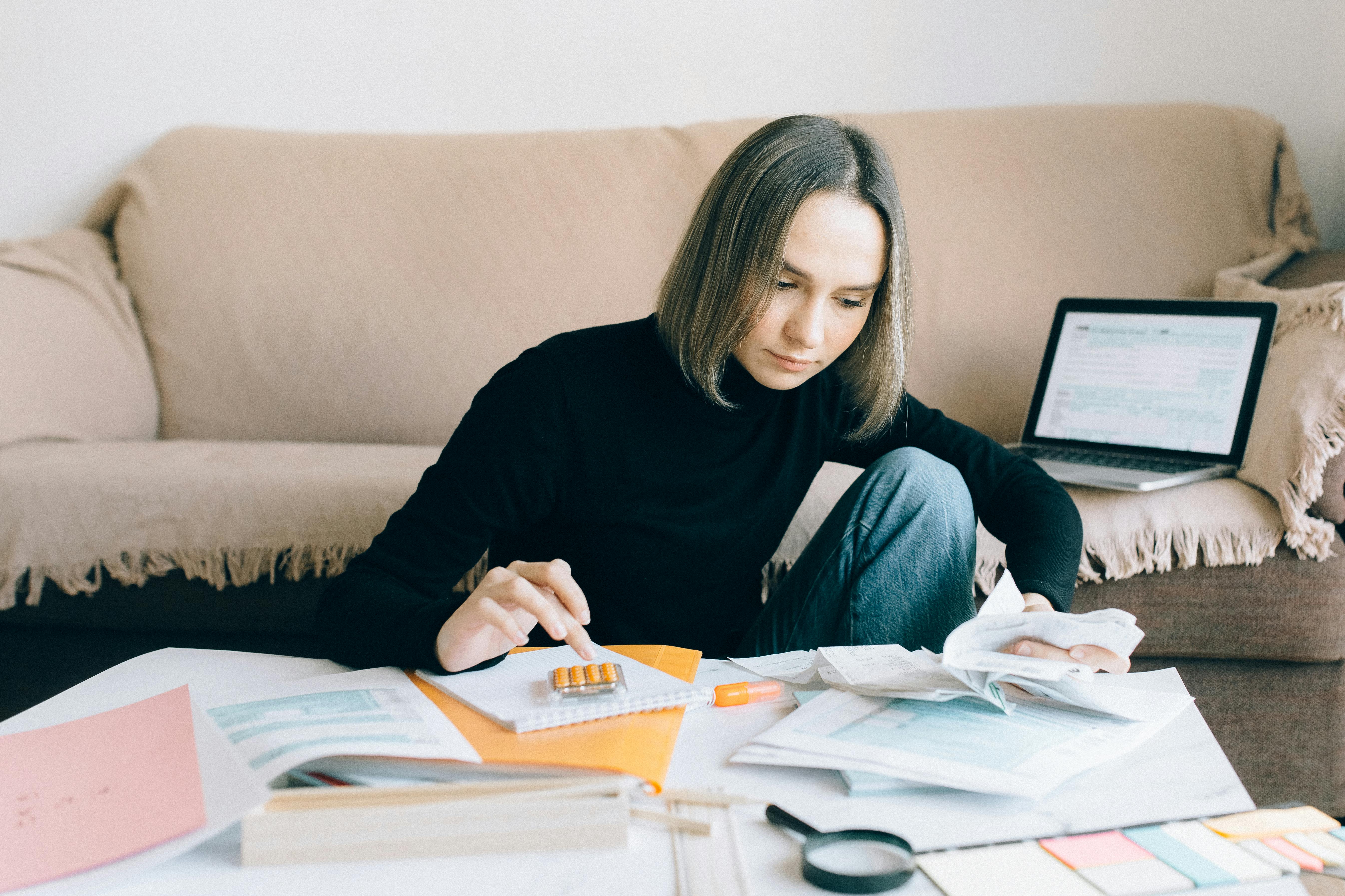 A nonprofit staff member works late, surrounded by paperwork and financial documents, illustrating the intense pressure and potential for burnout in grant writing.