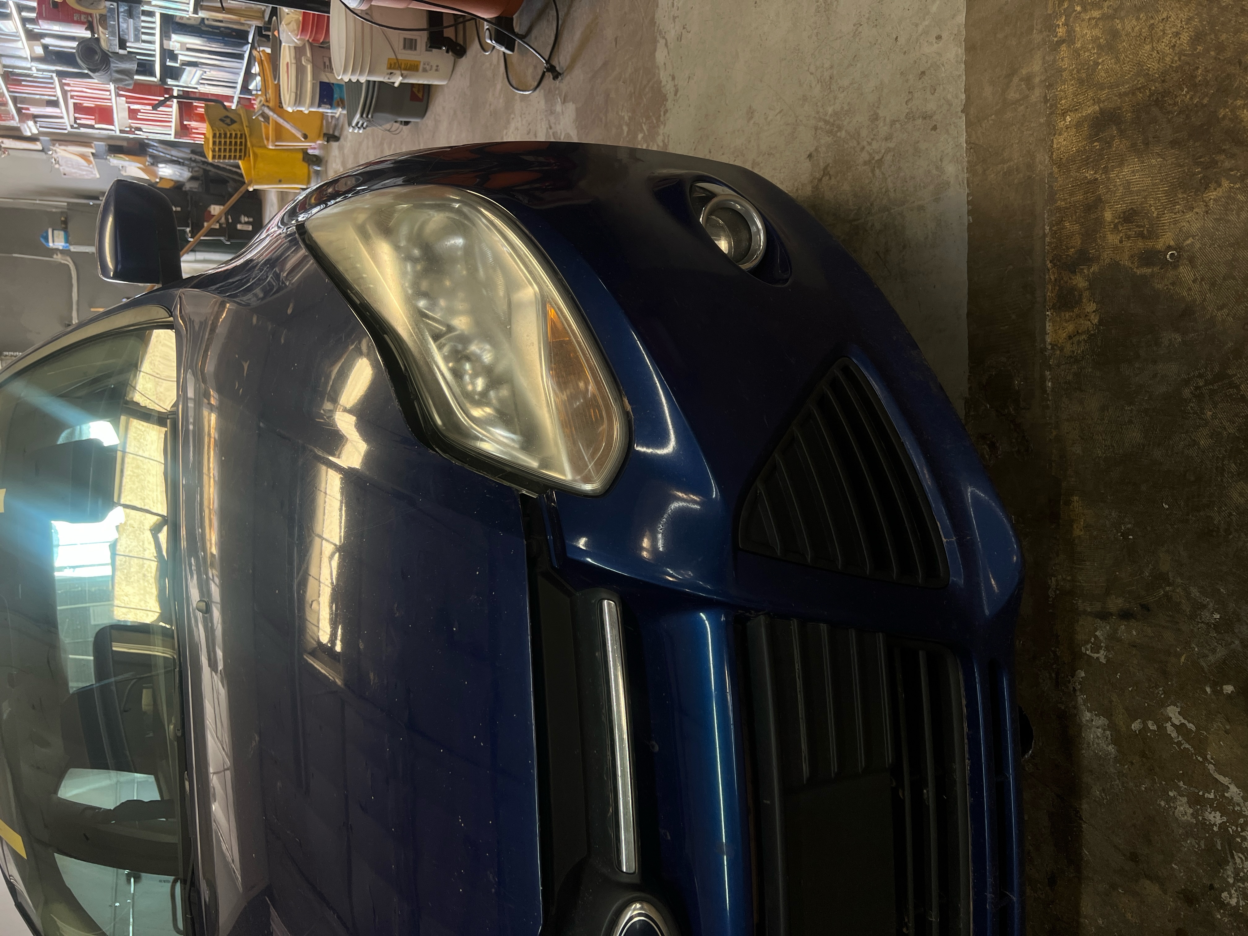 "Close-up image of a car's headlights being professionally restored at RND Auto Detailing. The left headlight appears clear and polished, showcasing the finished result, while the right headlight is still foggy and oxidized, highlighting the before-and-after difference. The setting emphasizes attention to detail and quality service." "Close-up image of a car's headlights being professionally restored at RND Auto Detailing. The left headlight appears clear and polished, showcasing the finished result, while the right headlight is still foggy and oxidized, highlighting the before-and-after difference. The setting emphasizes attention to detail and quality service."