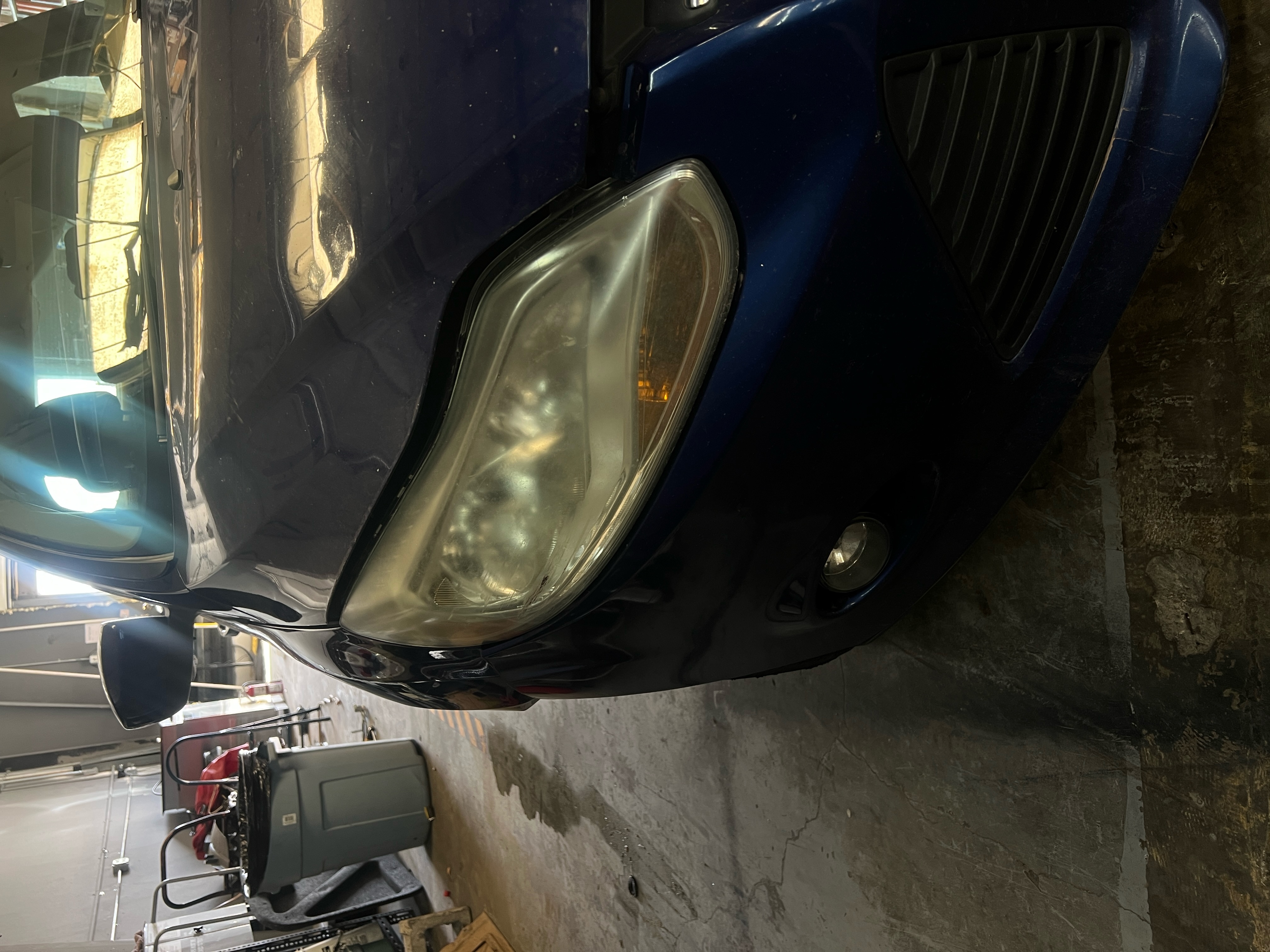 "Close-up image of a car's headlights being professionally restored at RND Auto Detailing. The left headlight appears clear and polished, showcasing the finished result, while the right headlight is still foggy and oxidized, highlighting the before-and-after difference. The setting emphasizes attention to detail and quality service." "Close-up image of a car's headlights being professionally restored at RND Auto Detailing. The left headlight appears clear and polished, showcasing the finished result, while the right headlight is still foggy and oxidized, highlighting the before-and-after difference. The setting emphasizes attention to detail and quality service."