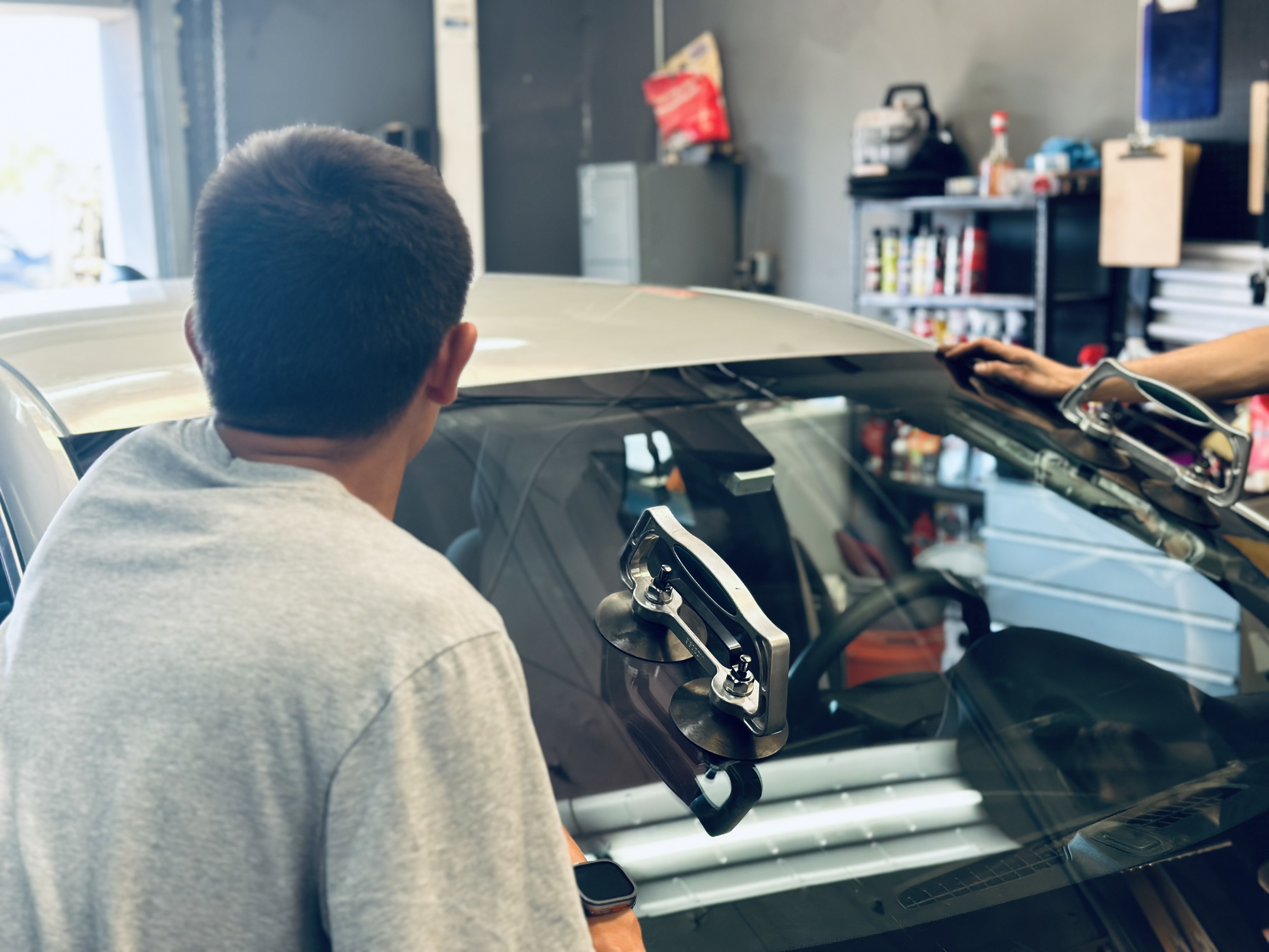 “Certified RND technician recalibrating advanced driver-assist sensors after windshield installation on a BMW.” “Certified RND technician recalibrating advanced driver-assist sensors after windshield installation on a BMW.”