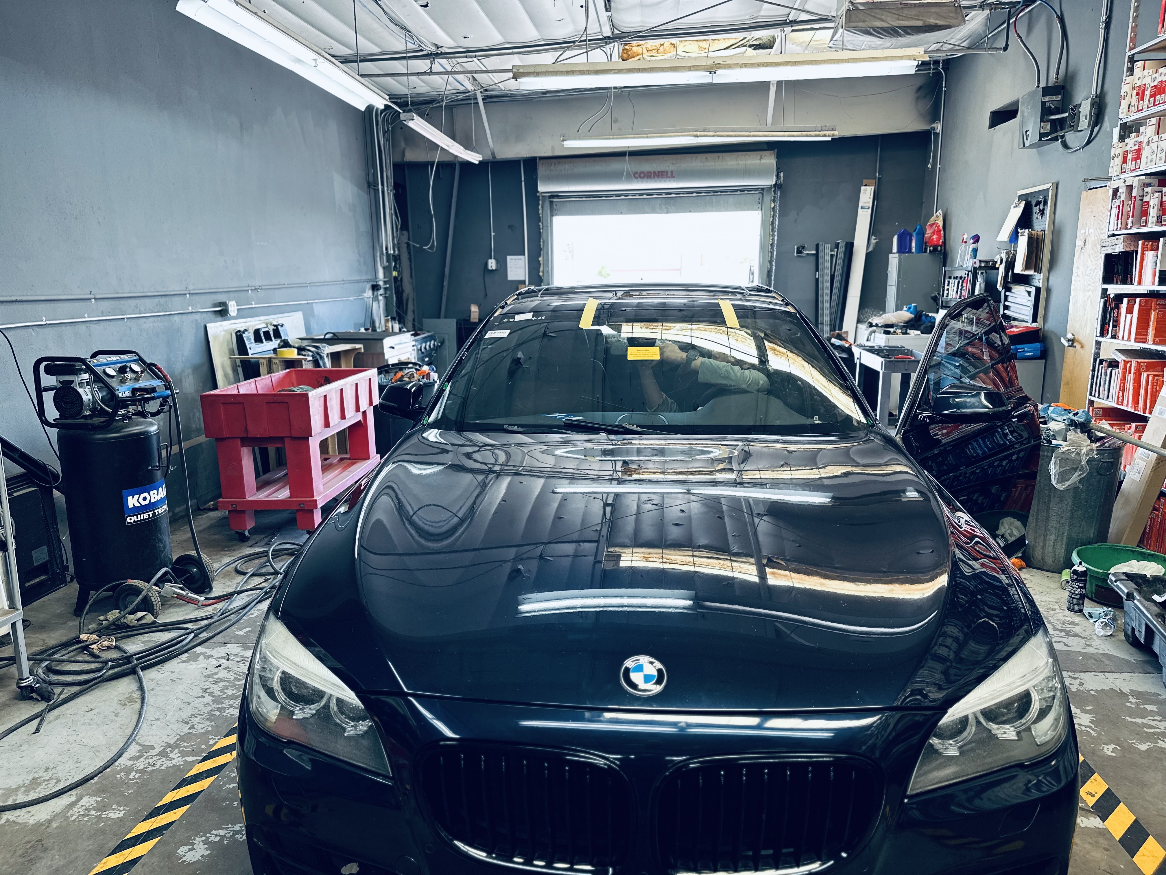 “RND Auto technician carefully replacing the cracked windshield on a 2018 BMW 3 Series in the repair bay.” “RND Auto technician carefully replacing the cracked windshield on a 2018 BMW 3 Series in the repair bay.”