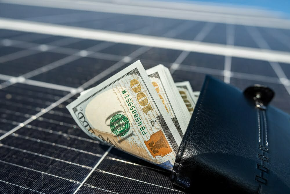 A close-up image of sleek solar panels under a bright Salem, Utah, sky, with a stack of $100 bills spilling out of a black wallet in the foreground, symbolizing the financial benefits of solar. The scene highlights how Ask Solar Mike helps Salem homeowners turn their solar systems into a profitable business with tax savings and a 2-3 year payback period. A close-up image of sleek solar panels under a bright Salem, Utah, sky, with a stack of $100 bills spilling out of a black wallet in the foreground, symbolizing the financial benefits of solar. The scene highlights how Ask Solar Mike helps Salem homeowners turn their solar systems into a profitable business with tax savings and a 2-3 year payback period.