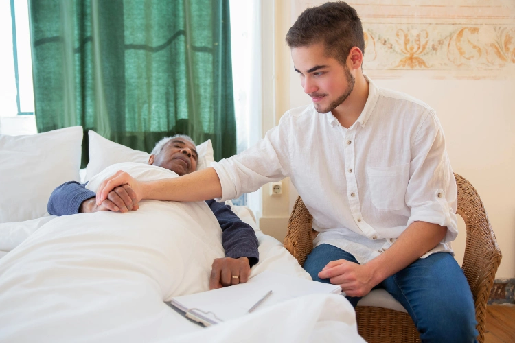 male live-in caregiver monitoring elderly man during sleep