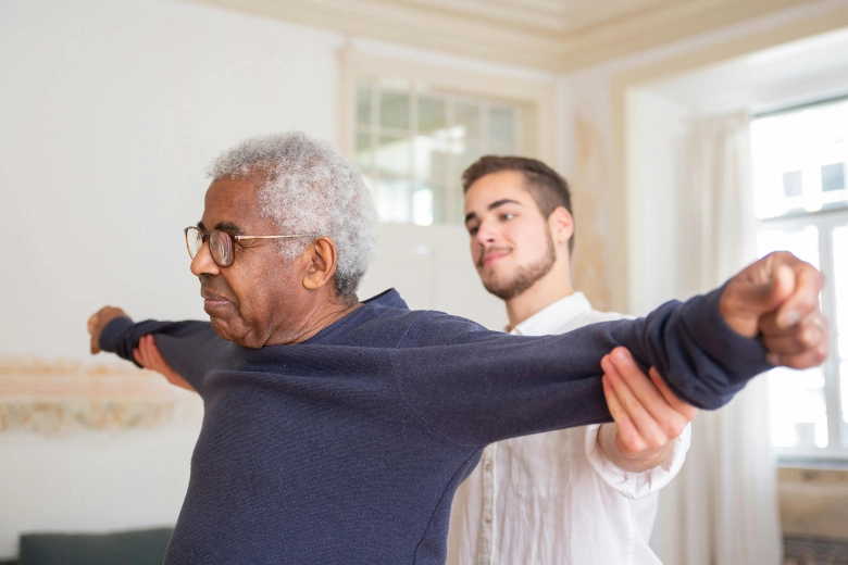 A caregiver helps a male client do balance training to aid in fall prevention, provided by Preferred Care at Home through Sumner In-Home Care