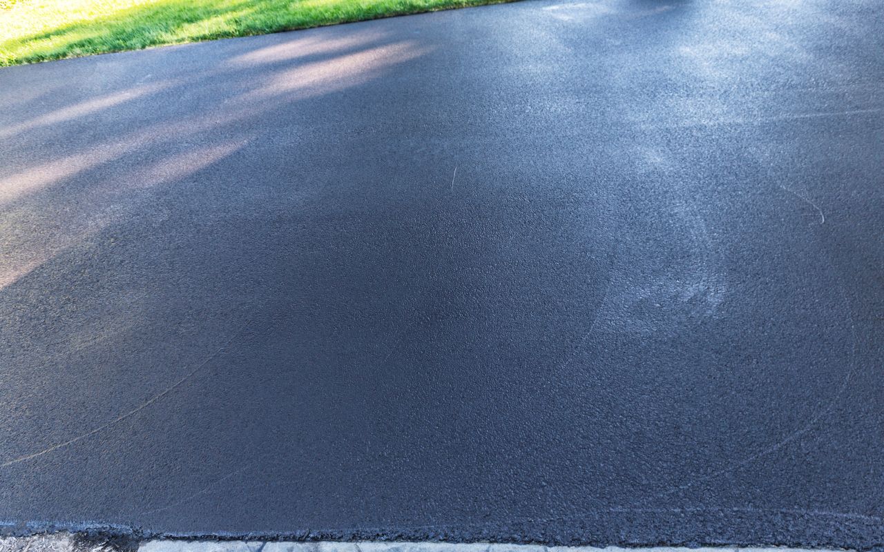 Enhanced appearance of an asphalt driveway after sealcoating