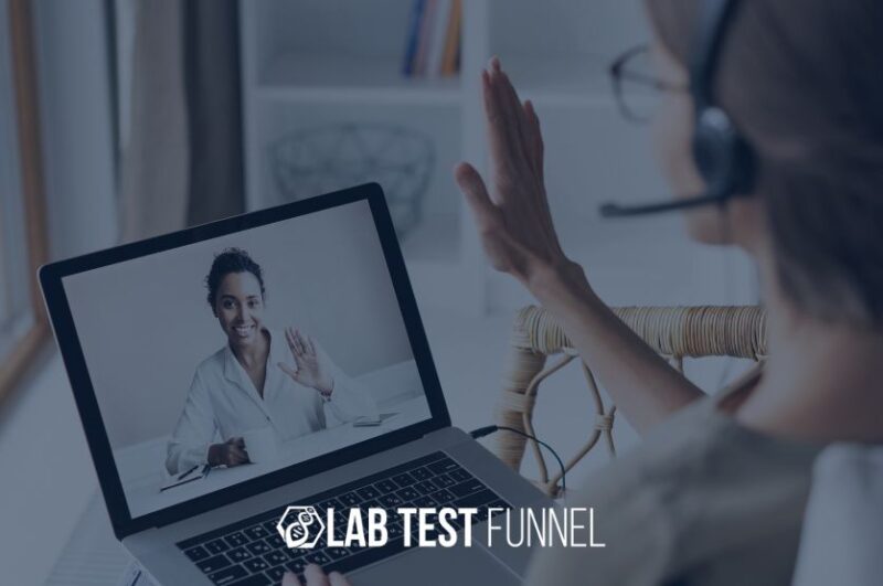 Over-the-shoulder view of a client wearing a headset and waving at a laptop screen during a video call with a smiling female health practitioner who is waving back, with the "Lab Test Funnel" logo in the foreground.