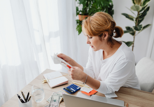 Small business owner staring at receipts and bookkeeping software after closing