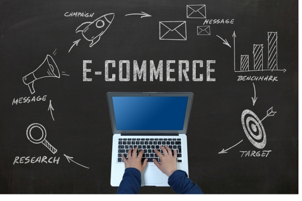 A laptop on a chalkboard background labeled ‘E-Commerce,’ surrounded by hand-drawn icons for campaign, benchmark, target, and research, symbolizing key strategies for successful online business A laptop on a chalkboard background labeled ‘E-Commerce,’ surrounded by hand-drawn icons for campaign, benchmark, target, and research, symbolizing key strategies for successful online business