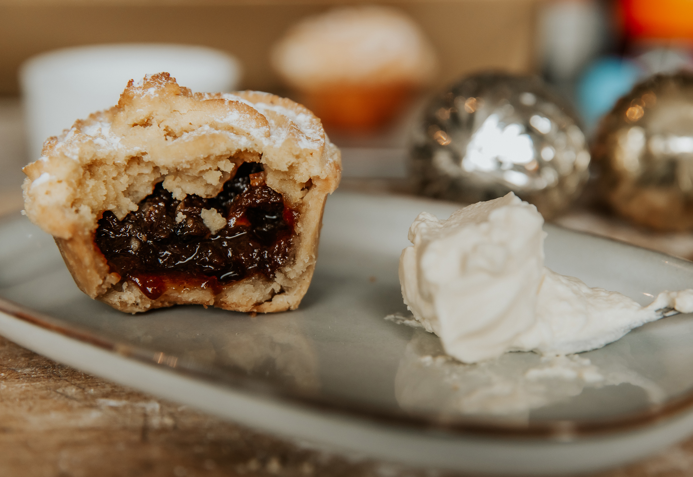 A minced pie cut open with a dollop of cream